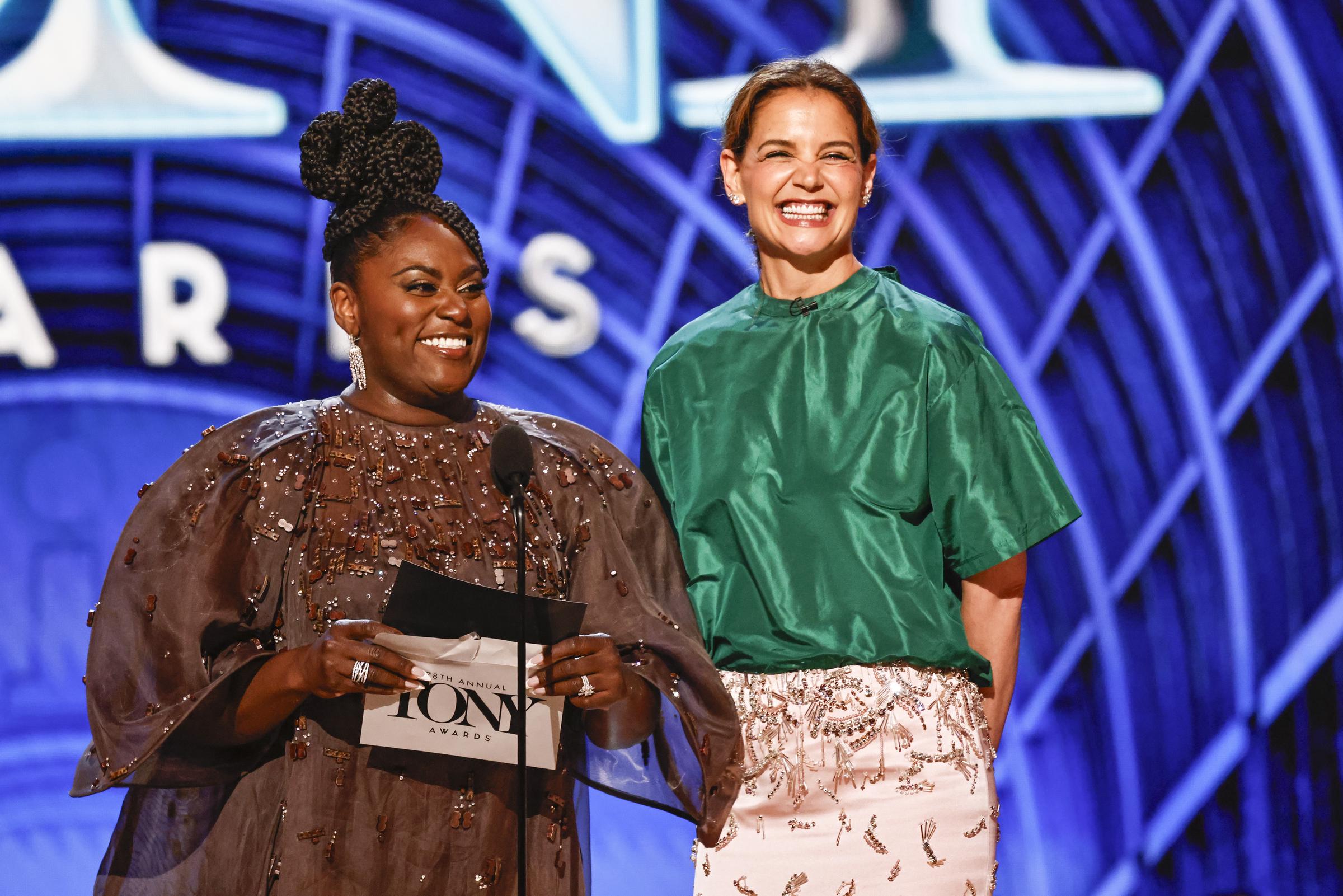 Freudestrahlend teilt Katie Holmes ein Lachen mit Danielle Brooks, während sie live auf der Bühne der Tony Awards moderiert. Die beiden sorgten mit Charme und Charisma für einen der herausragenden Moderationsmomente des Abends.