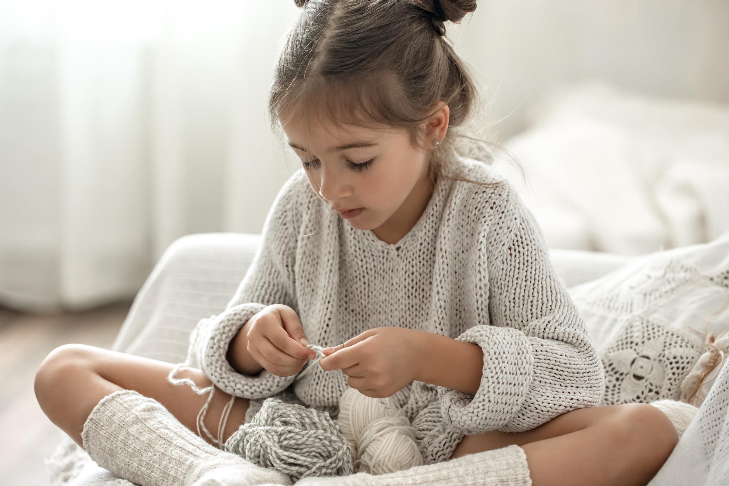 Ein kleines Mädchen beim Stricken | Quelle: Freepik