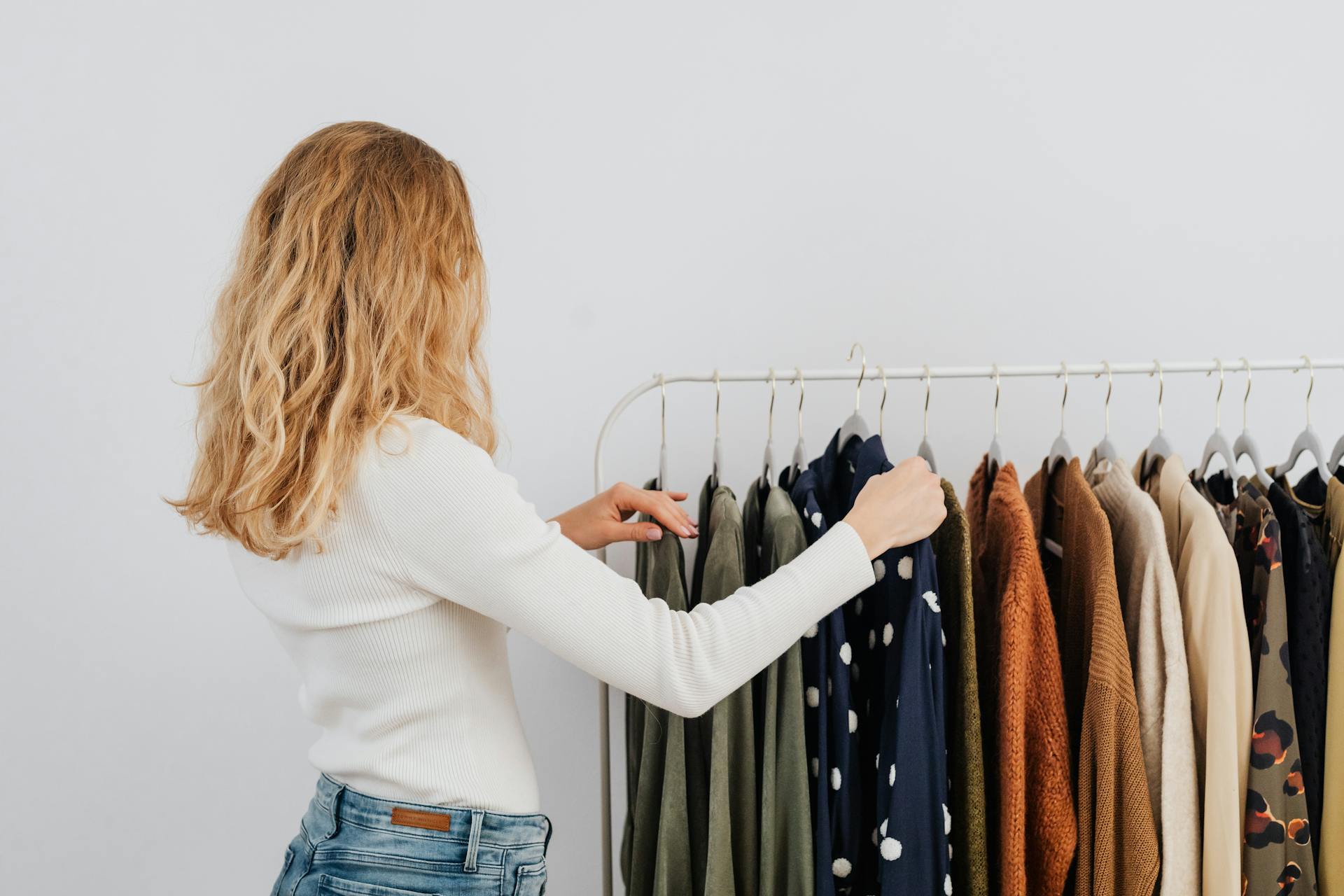 Eine Frau hängt Kleidung auf einen Ständer | Quelle: Pexels