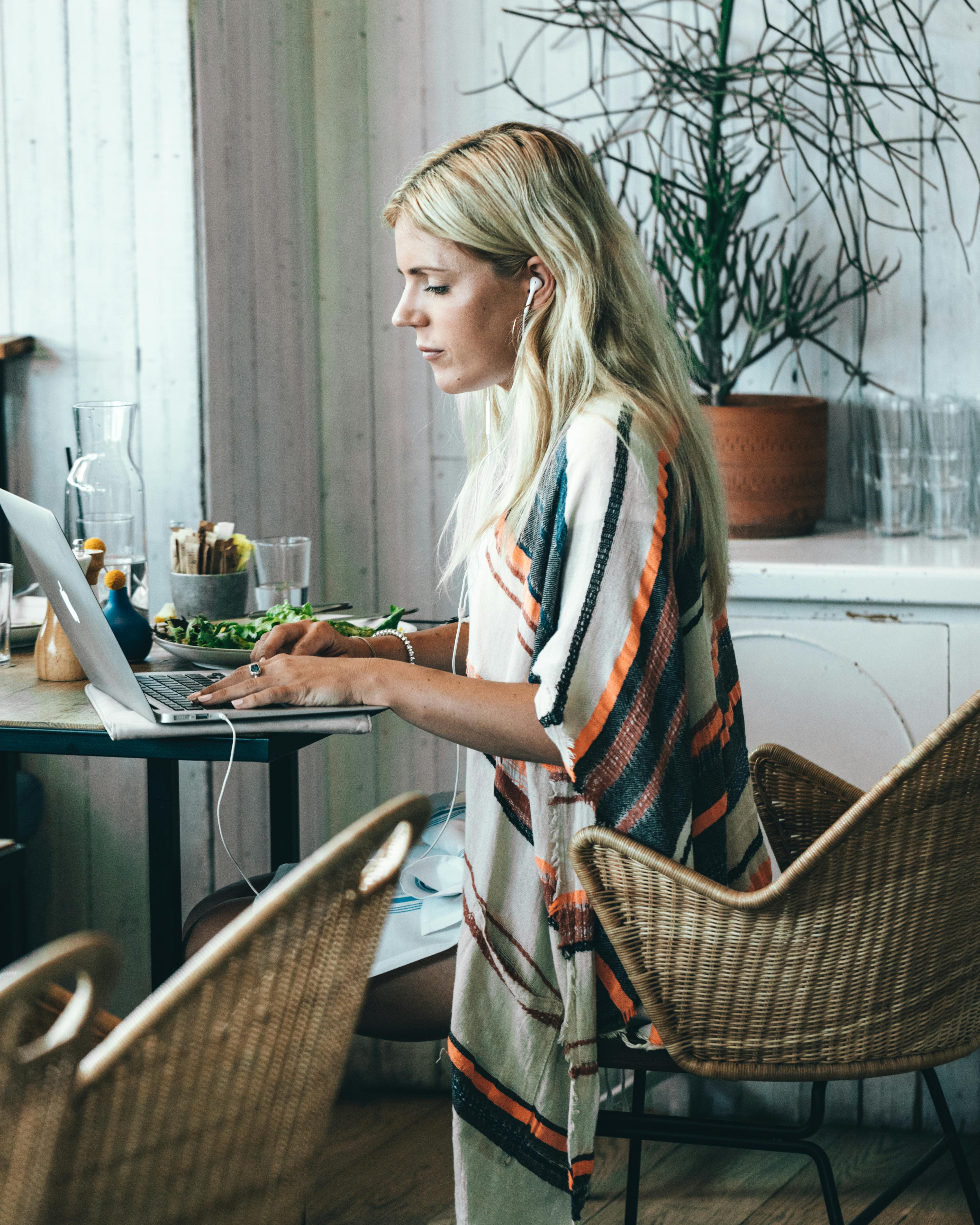 Eine Frau trägt Kopfhörer, während sie einen Laptop benutzt | Quelle: Pexels