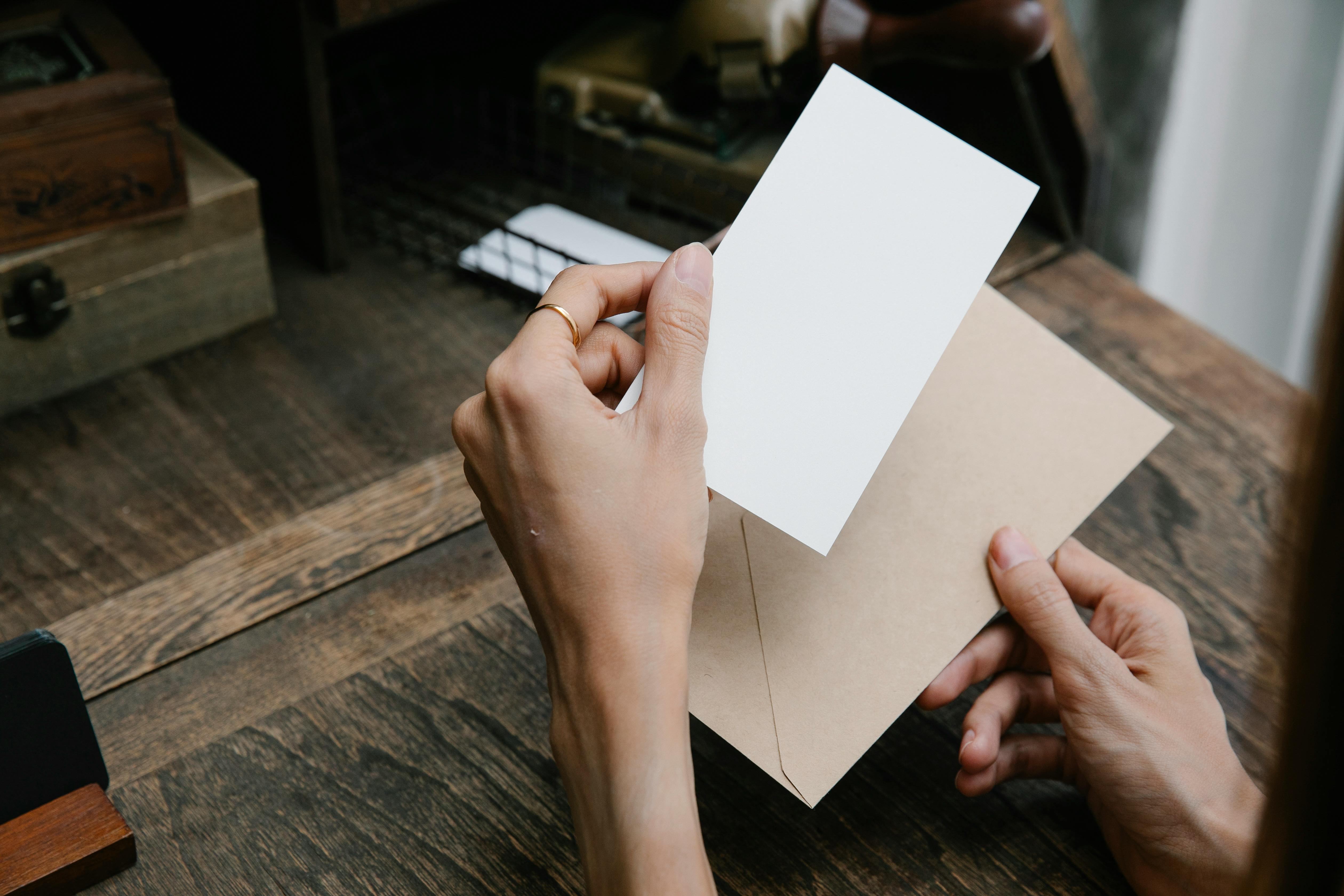 Eine Person hält ein Stück Papier und einen Umschlag in der Hand | Quelle: Pexels