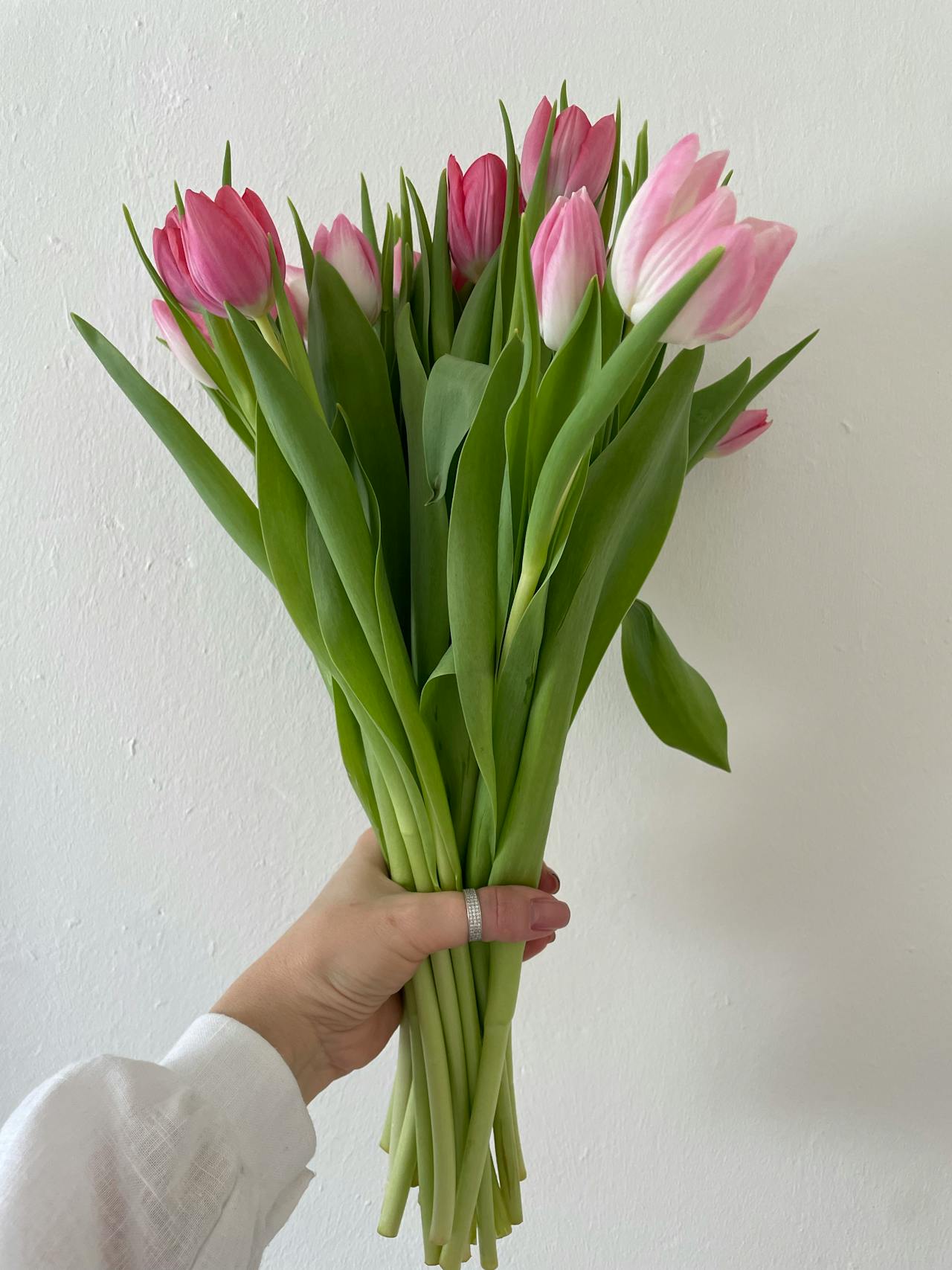Ausgeschnittene Aufnahme einer Frau mit einem Strauß rosa Tulpen | Quelle: Pexels