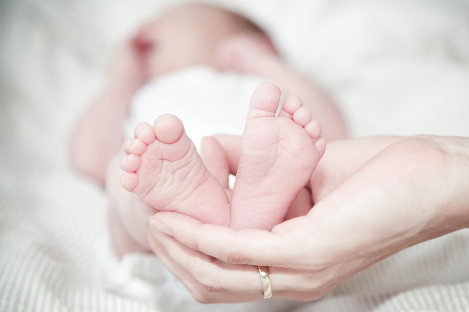 Eine Person, die die Füße eines Babys hält | Quelle: Pexels