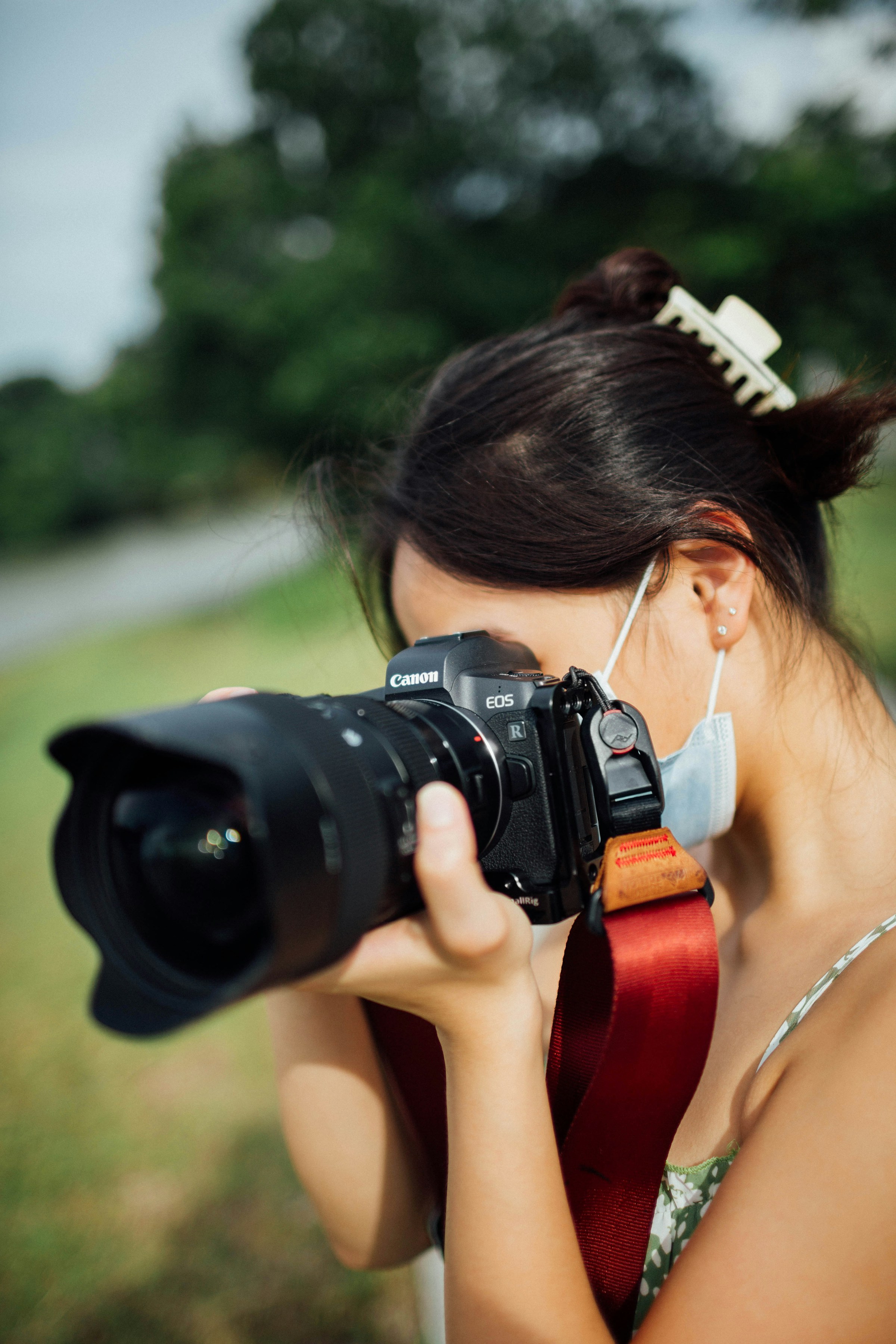 Eine Frau hält eine DSLR-Kamera | Quelle: Unsplash