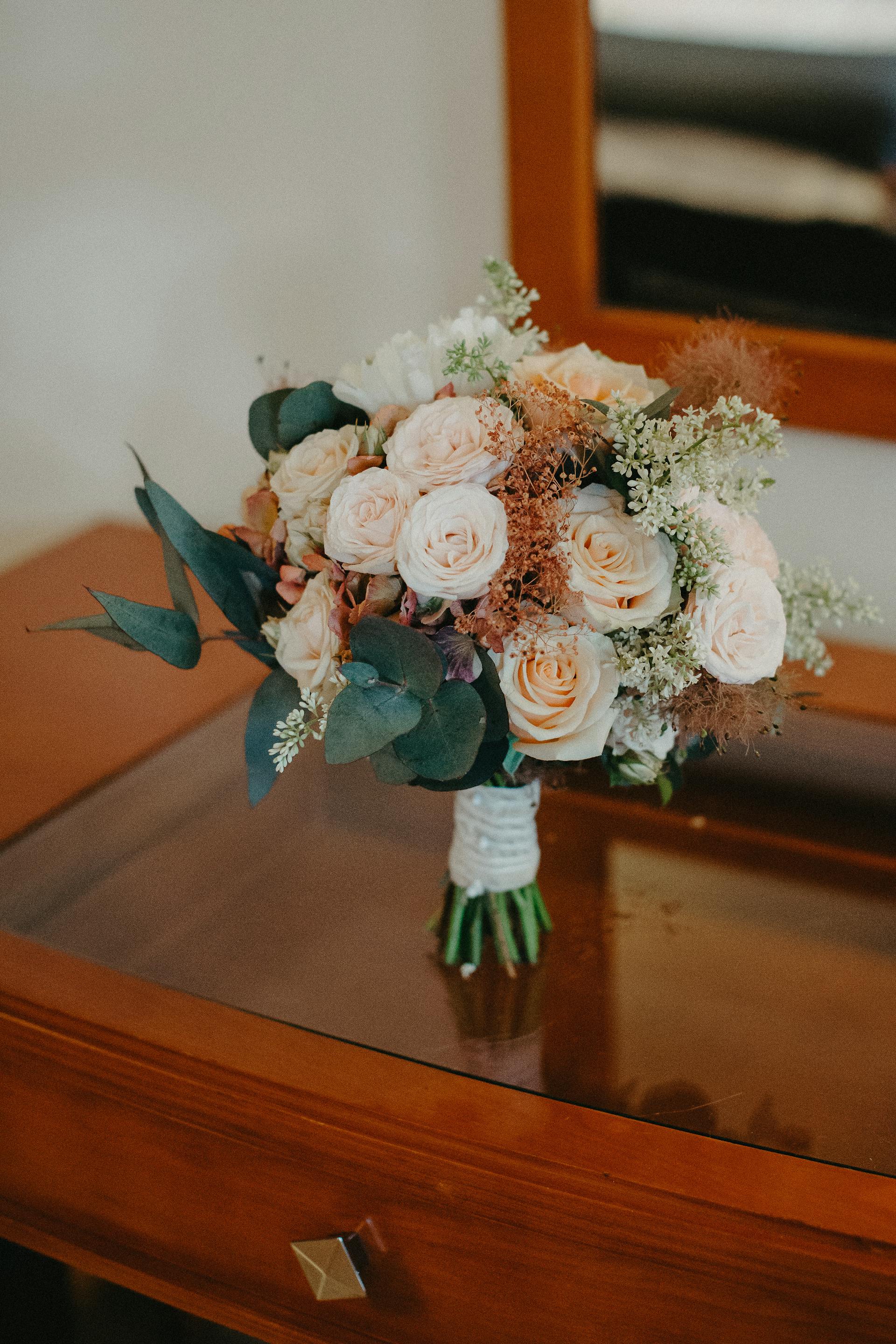 Ein Blumenstrauß aus Rosen auf einem Holztisch | Quelle: Pexels