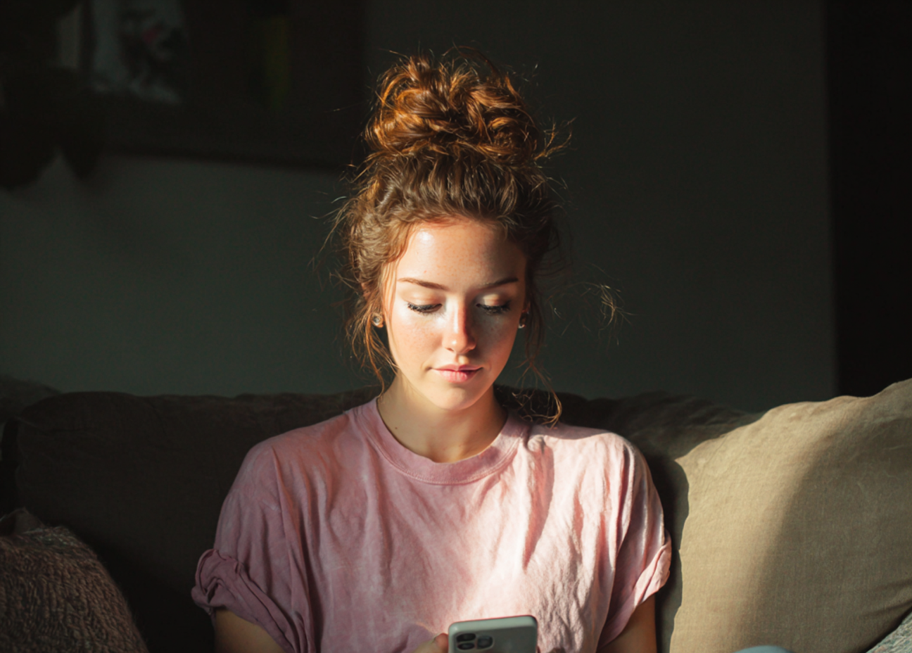 Eine Frau, die auf einer Couch sitzt und ihr Telefon benutzt | Quelle: Midjourney