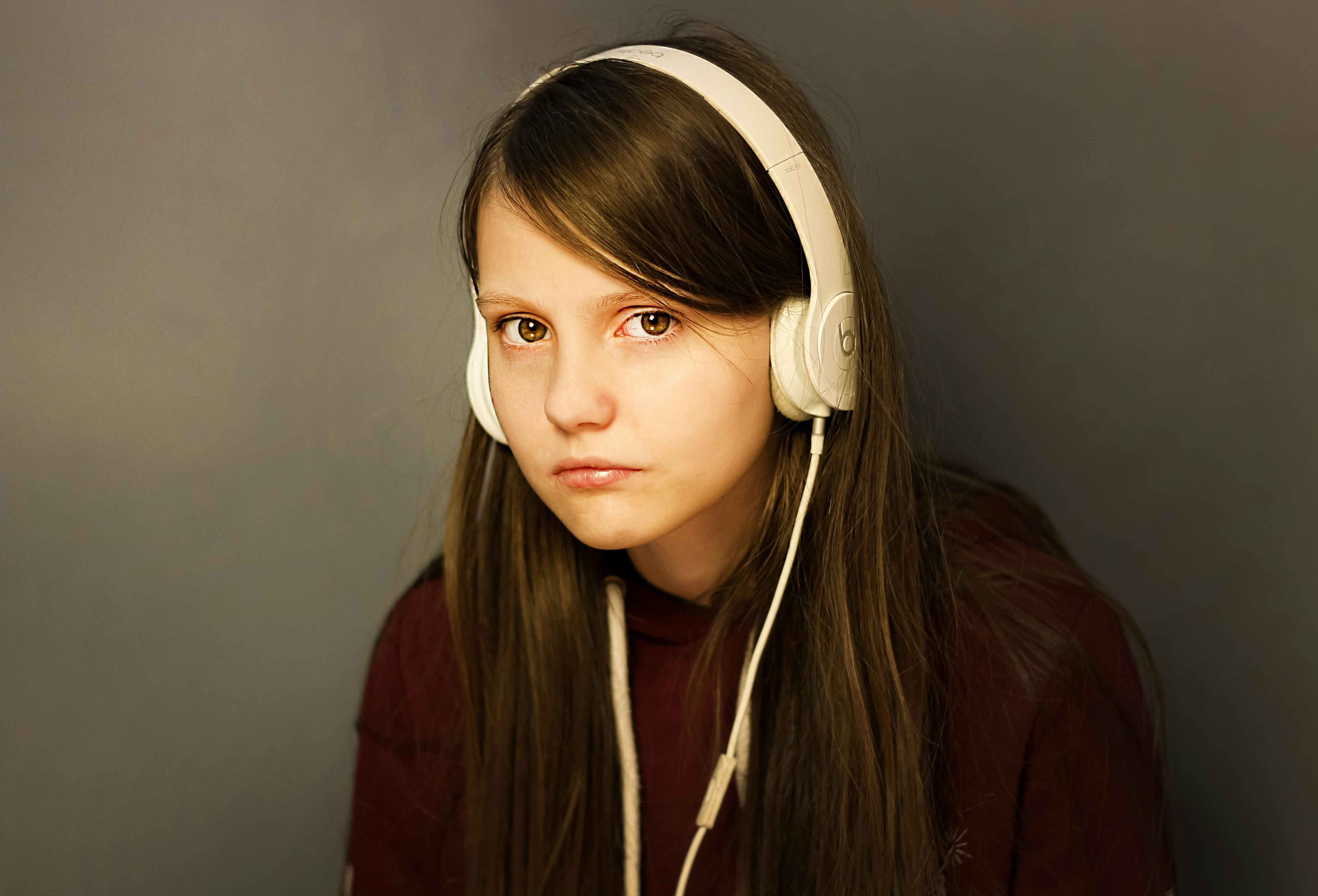 Ein emotionales Teenager-Mädchen mit Kopfhörern | Quelle: Unsplash