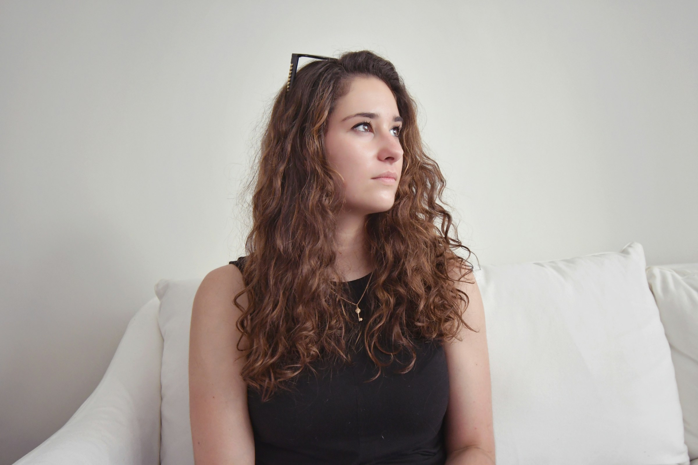 Eine Frau, die auf einem Sofa sitzt und zur Seite schaut | Quelle: Unsplash