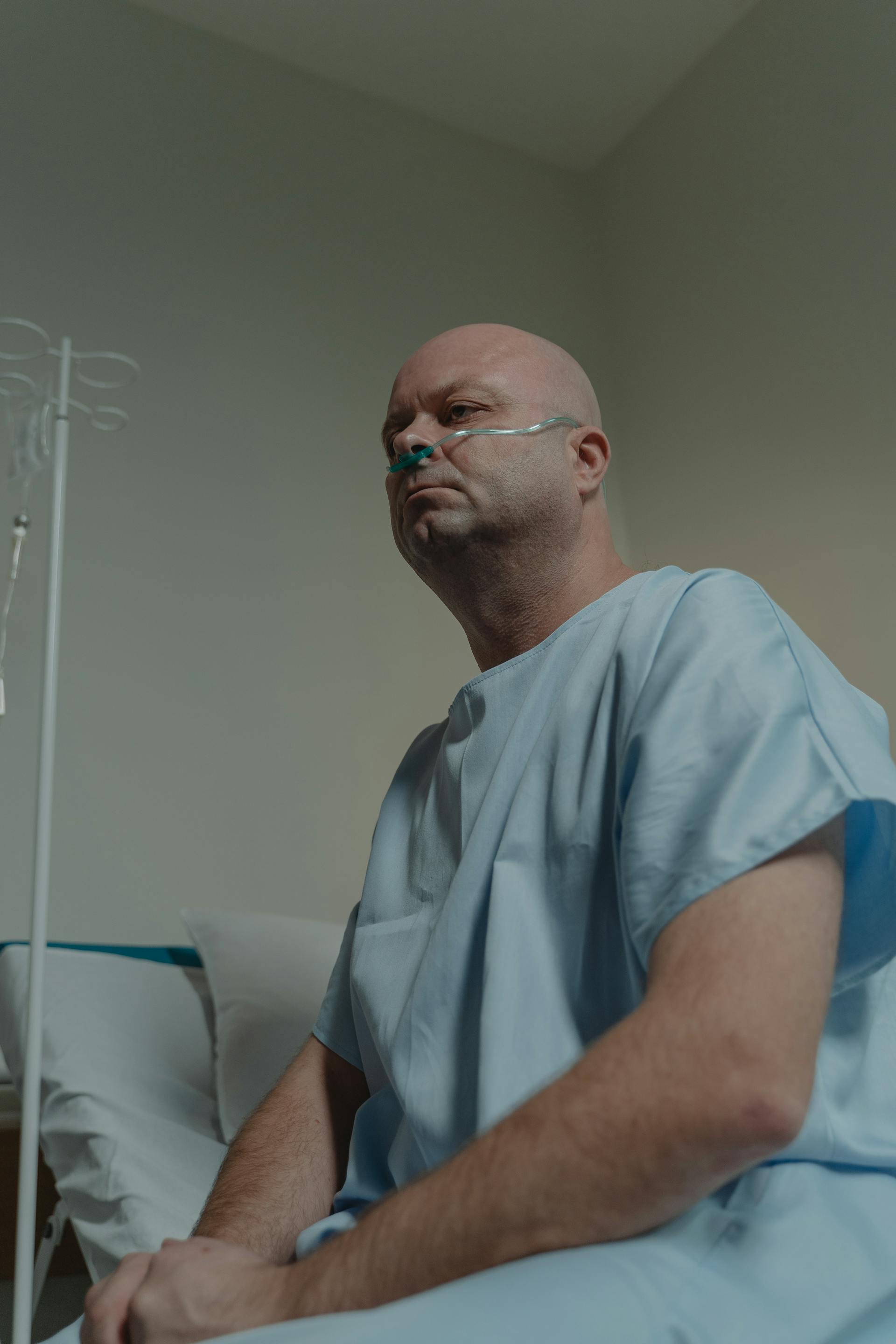 Ein kranker Mann sitzt auf einem Krankenhausbett | Quelle: Pexels