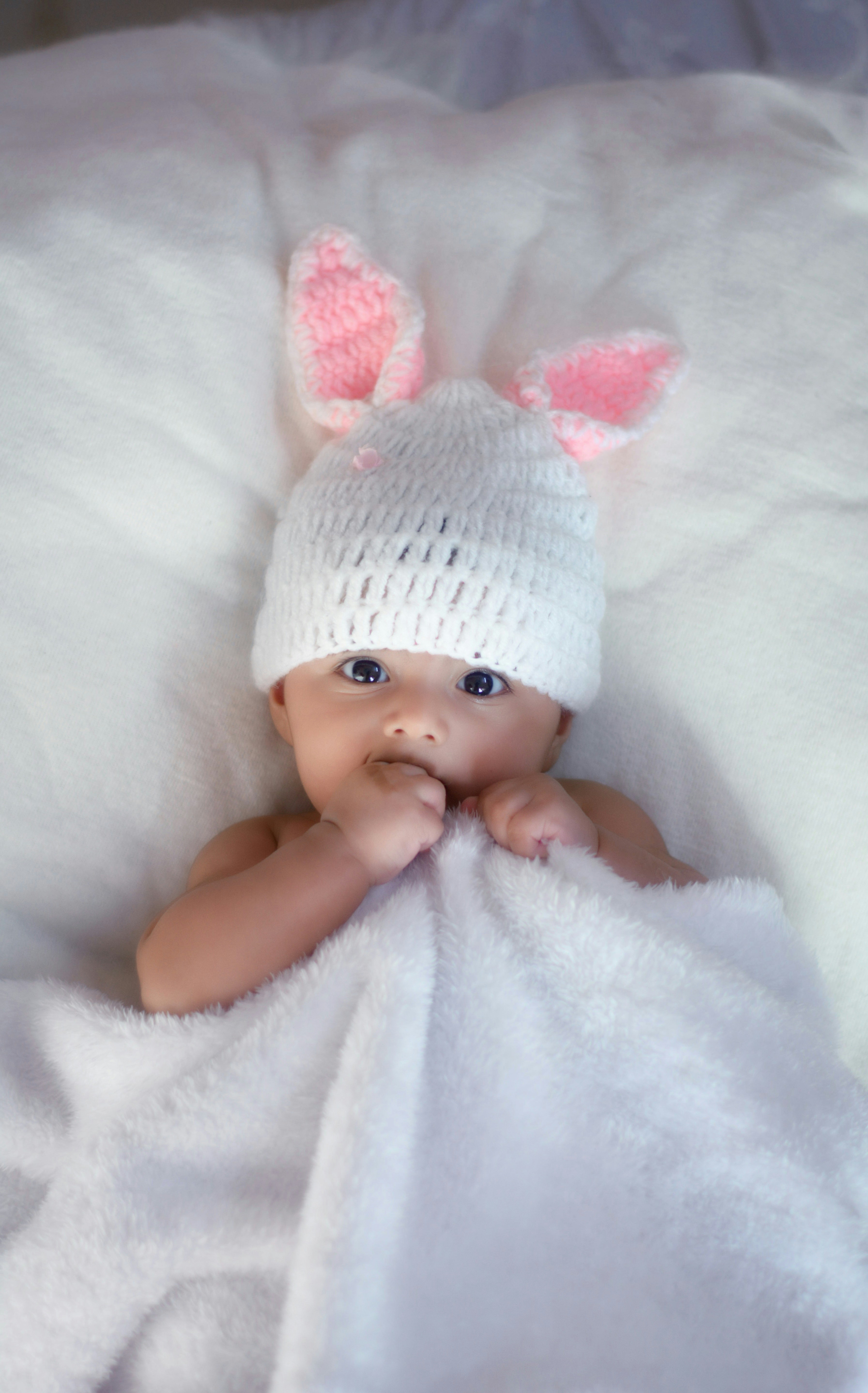Ein kleines Mädchen mit einer weißen Strickmütze | Quelle: Unsplash