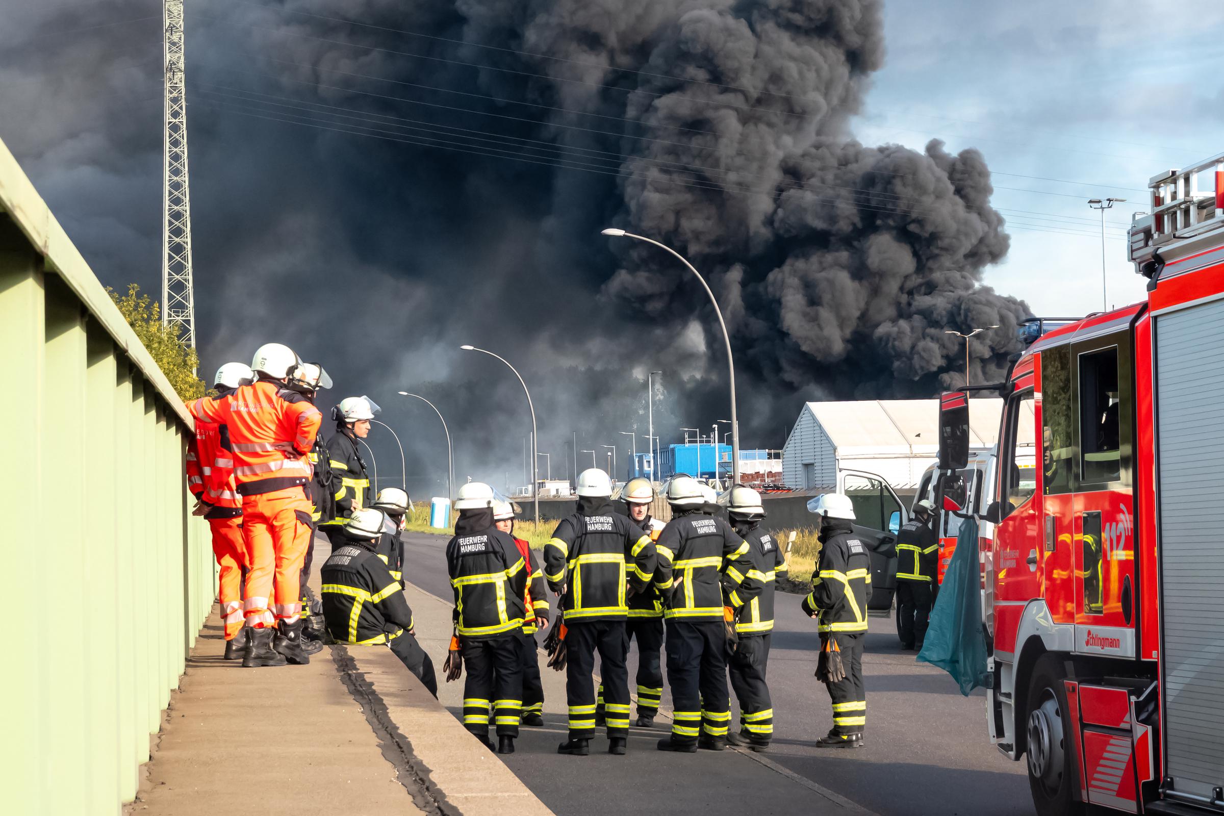 25. August 2025, Hamburg: Rettungskräfte der unterstützenden Flughafenfeuerwehr bereiten sich auf ihren Einsatz bei einem Großbrand vor. Nach einem Brandausbruch in einem Lagerhaus in einem Industriegebiet in Hamburg kam es zu mehreren Explosionen. | Quelle: Getty Images