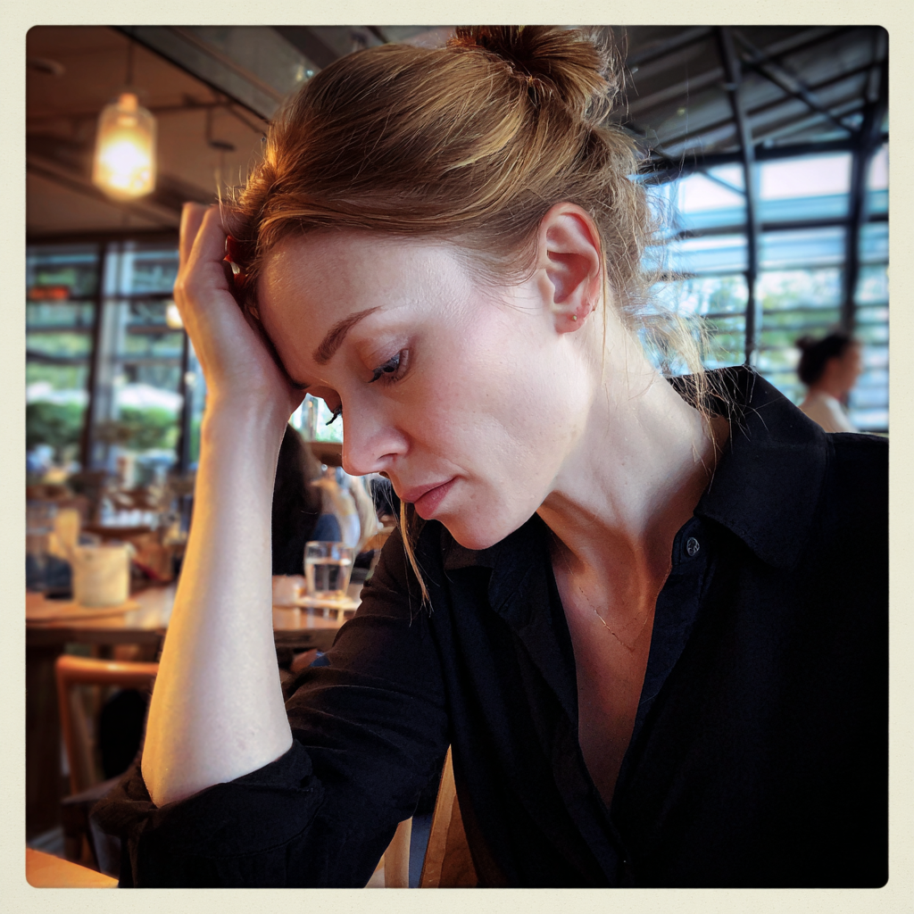 Eine Frau sitzt mit der Hand auf dem Kopf | Quelle: Midjourney