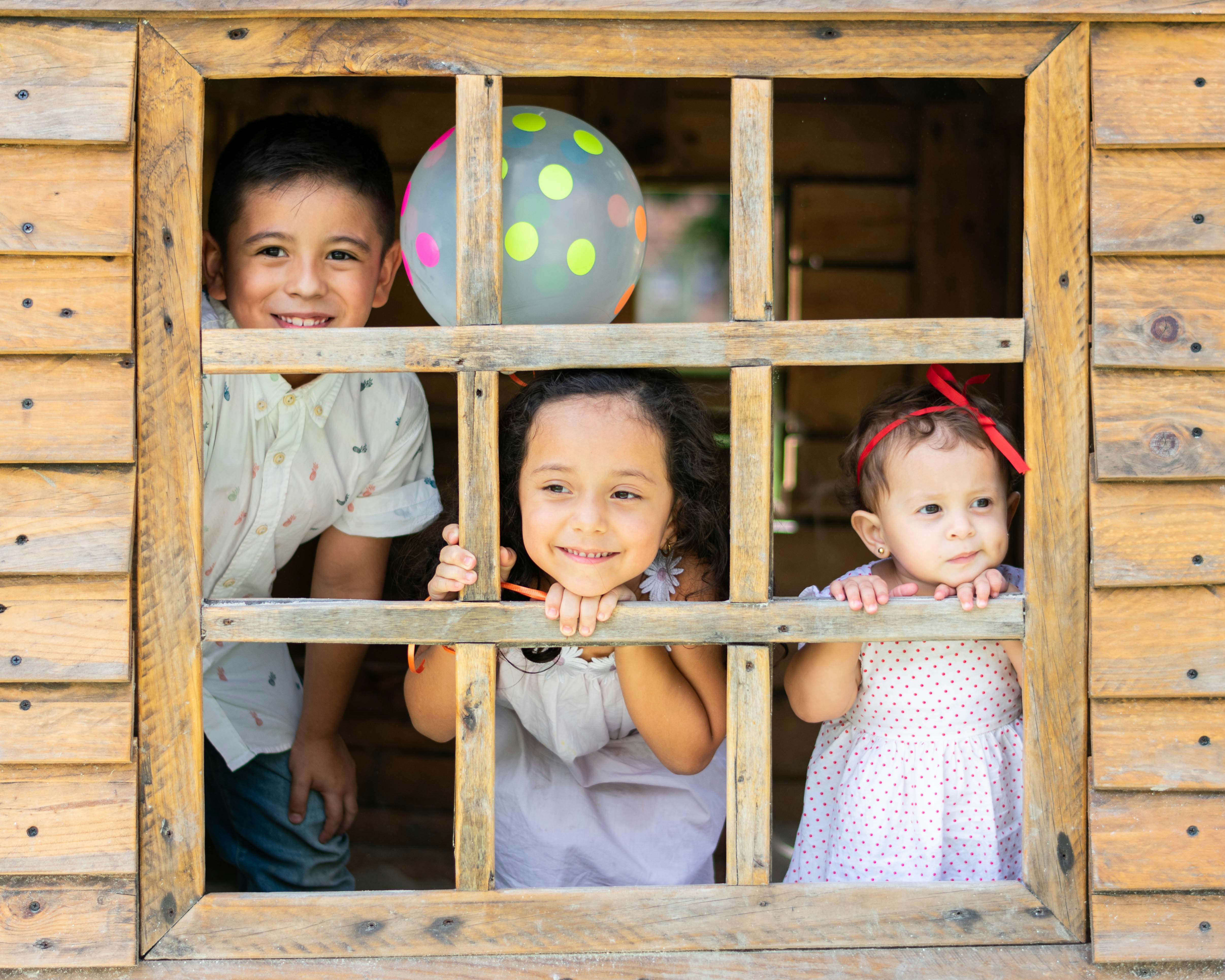 Kinder am Fenster einer Hütte | Quelle: Unsplash