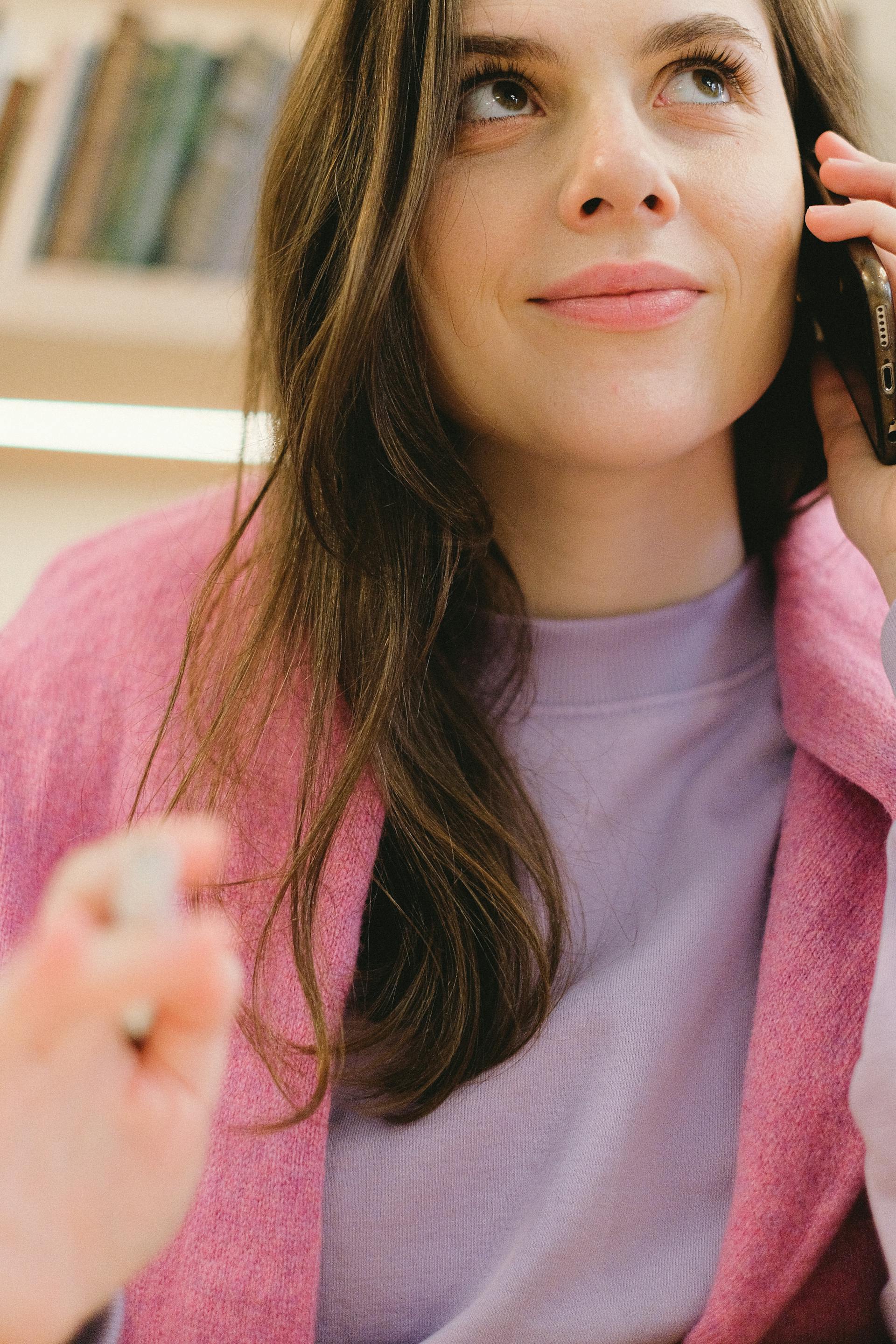 Eine Frau, die während eines Telefonats grimmig lächelt | Quelle: Pexels