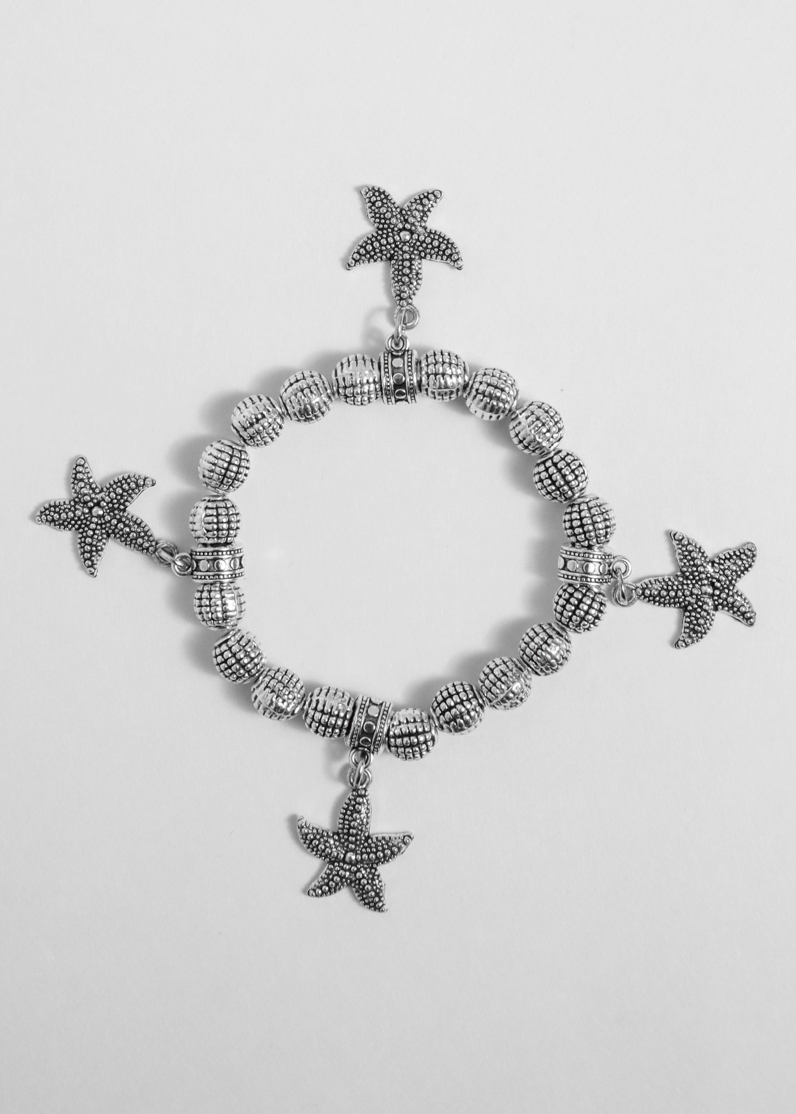 Ein Silberarmband mit Anhängern | Quelle: Unsplash