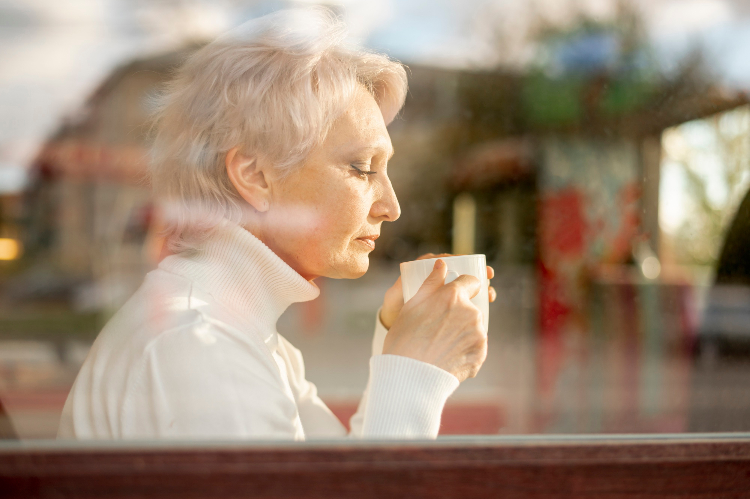 Eine ältere Frau hält eine weiße Keramiktasse | Quelle: Freepik