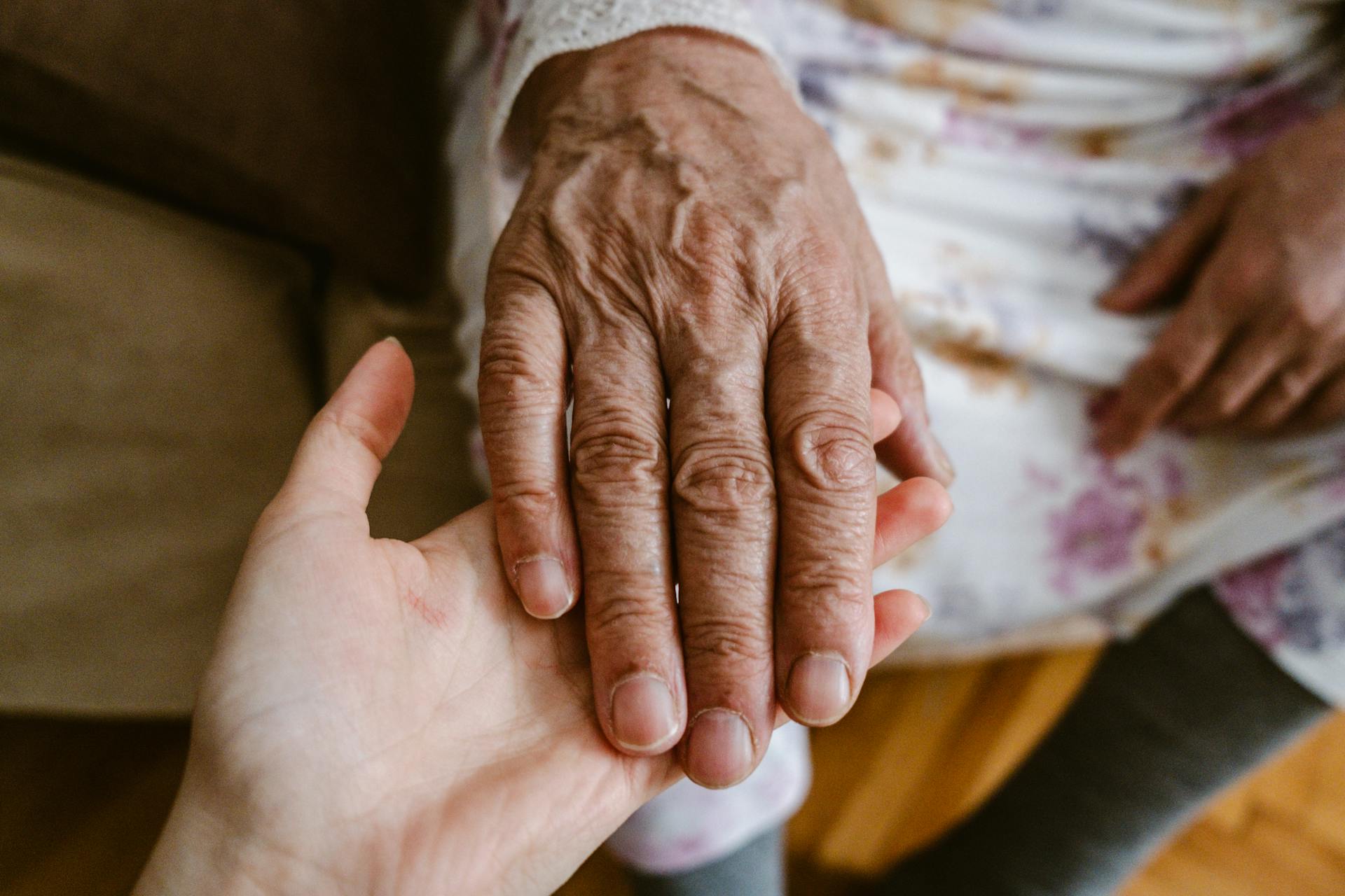 Eine Frau hält die Hand ihrer Mutter | Quelle: Midjourney