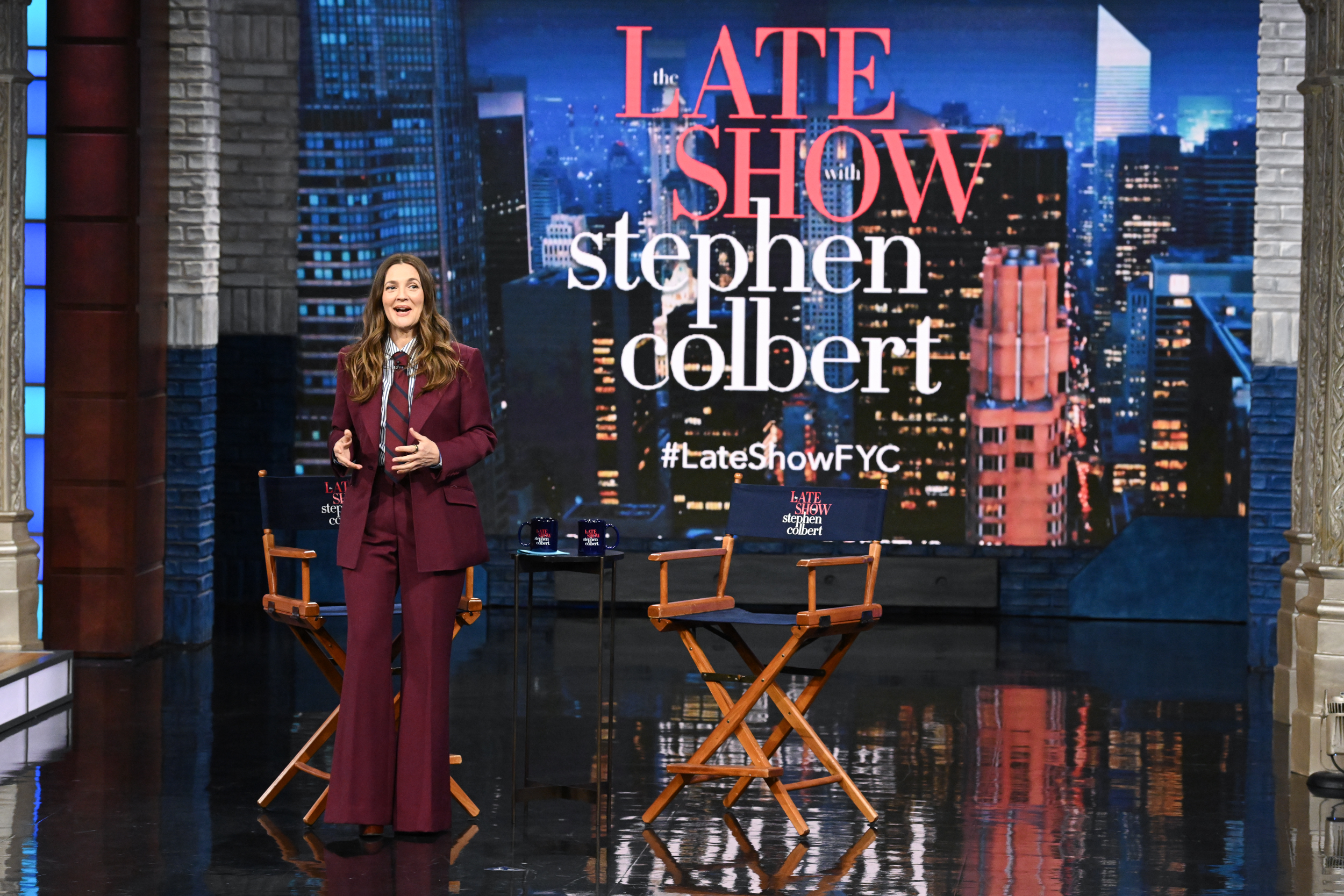 Drew Barrymore in einem eleganten burgunderroten Anzug während ihrer Moderation von „The Late Show with Stephen Colbert” am 1. Mai 2025.