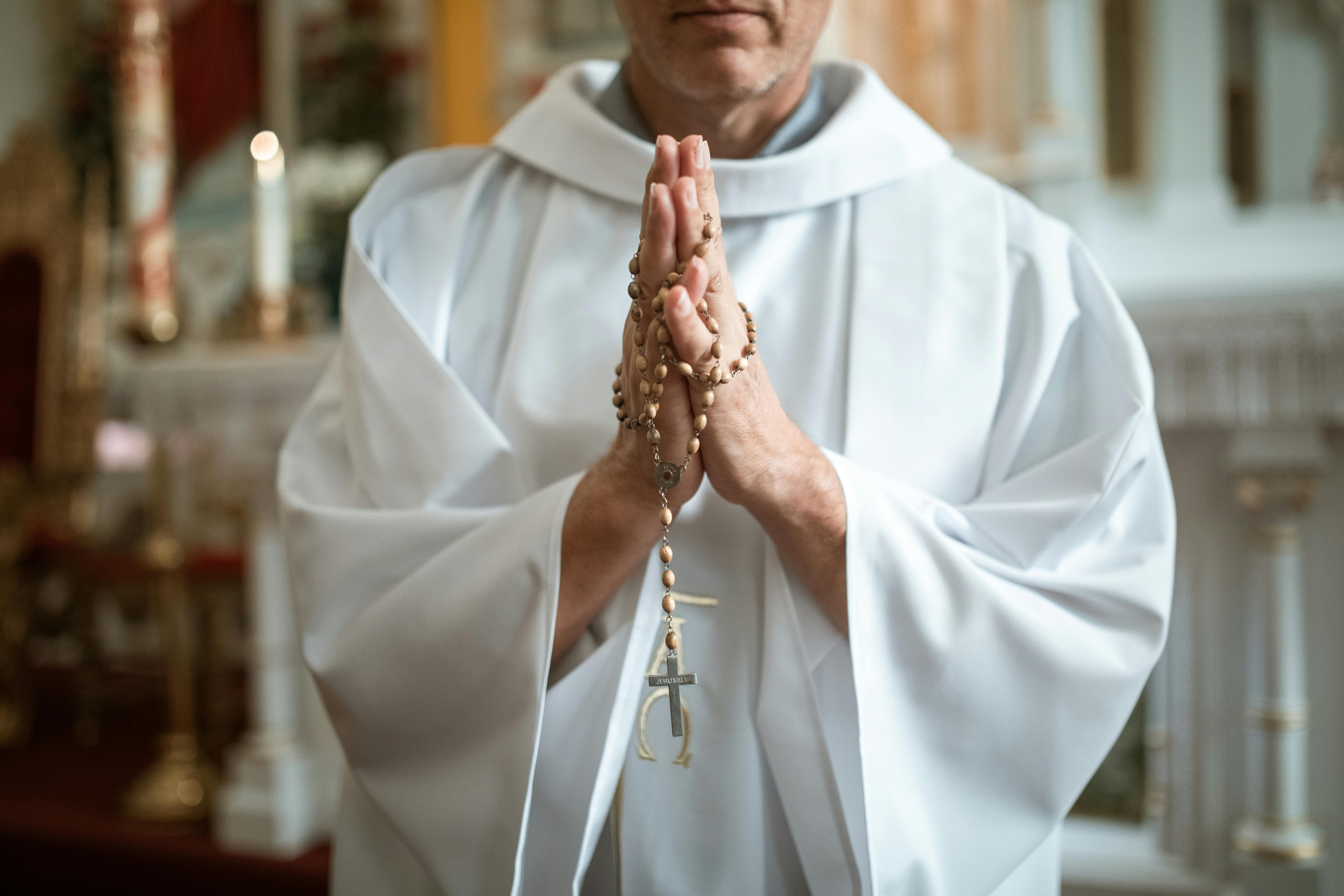 Ein Priester hält einen Rosenkranz | Quelle: Pexels