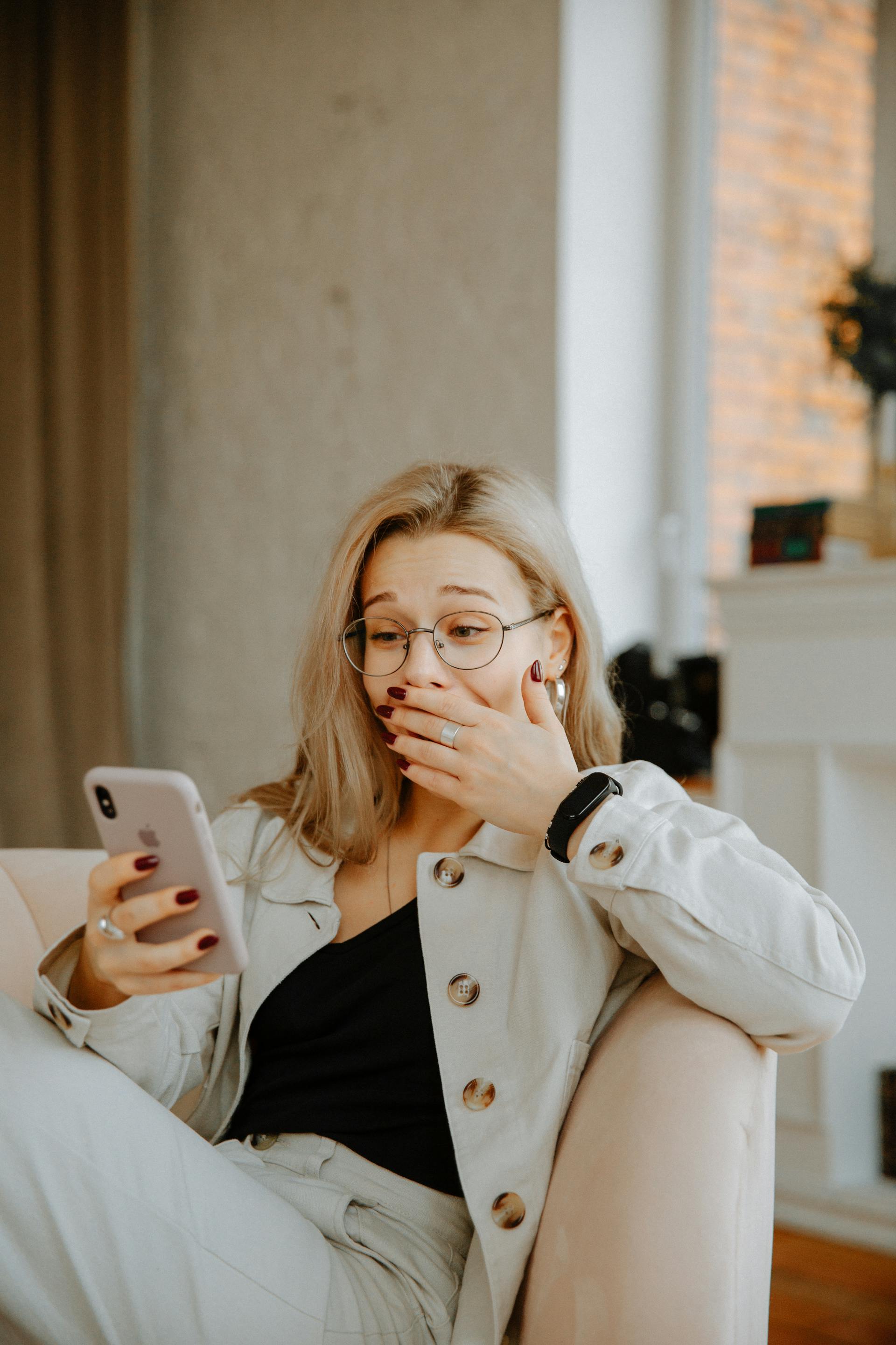 Eine schockierte und amüsierte Frau, die auf ihr Telefon schaut | Quelle: Pexels