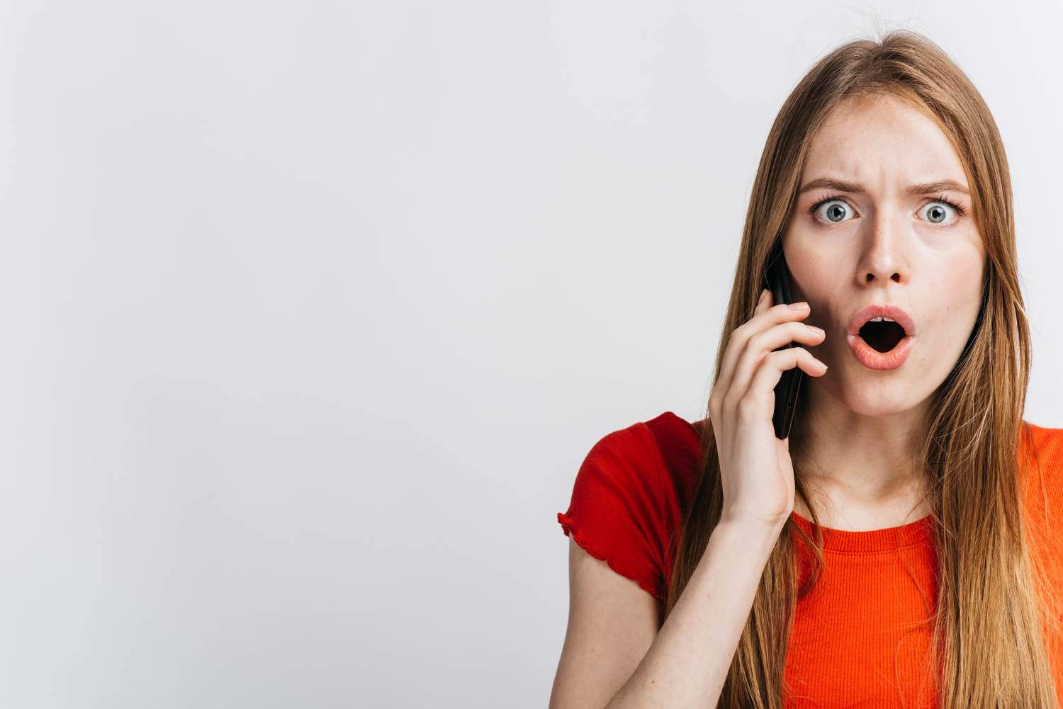 Eine erschrockene Frau beim Telefonieren | Quelle: Freepik