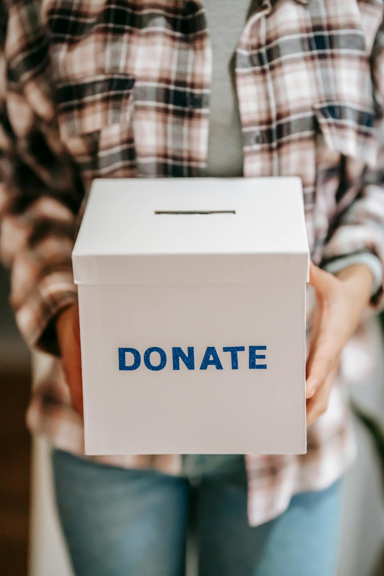 Eine Person hält eine Spendenbox | Quelle: Pexels
