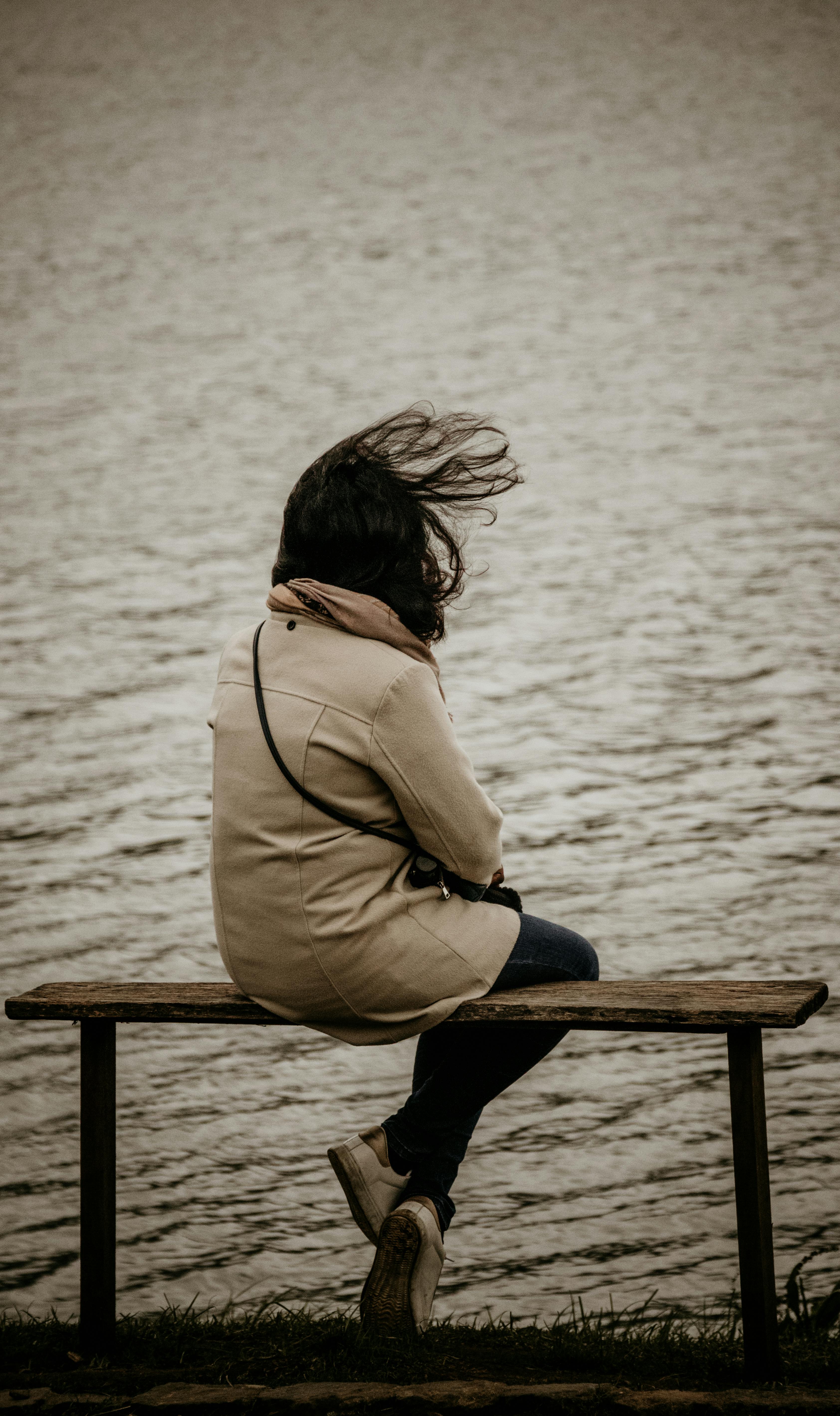 Frau sitzt auf einer Bank am See | Quelle: Pexels