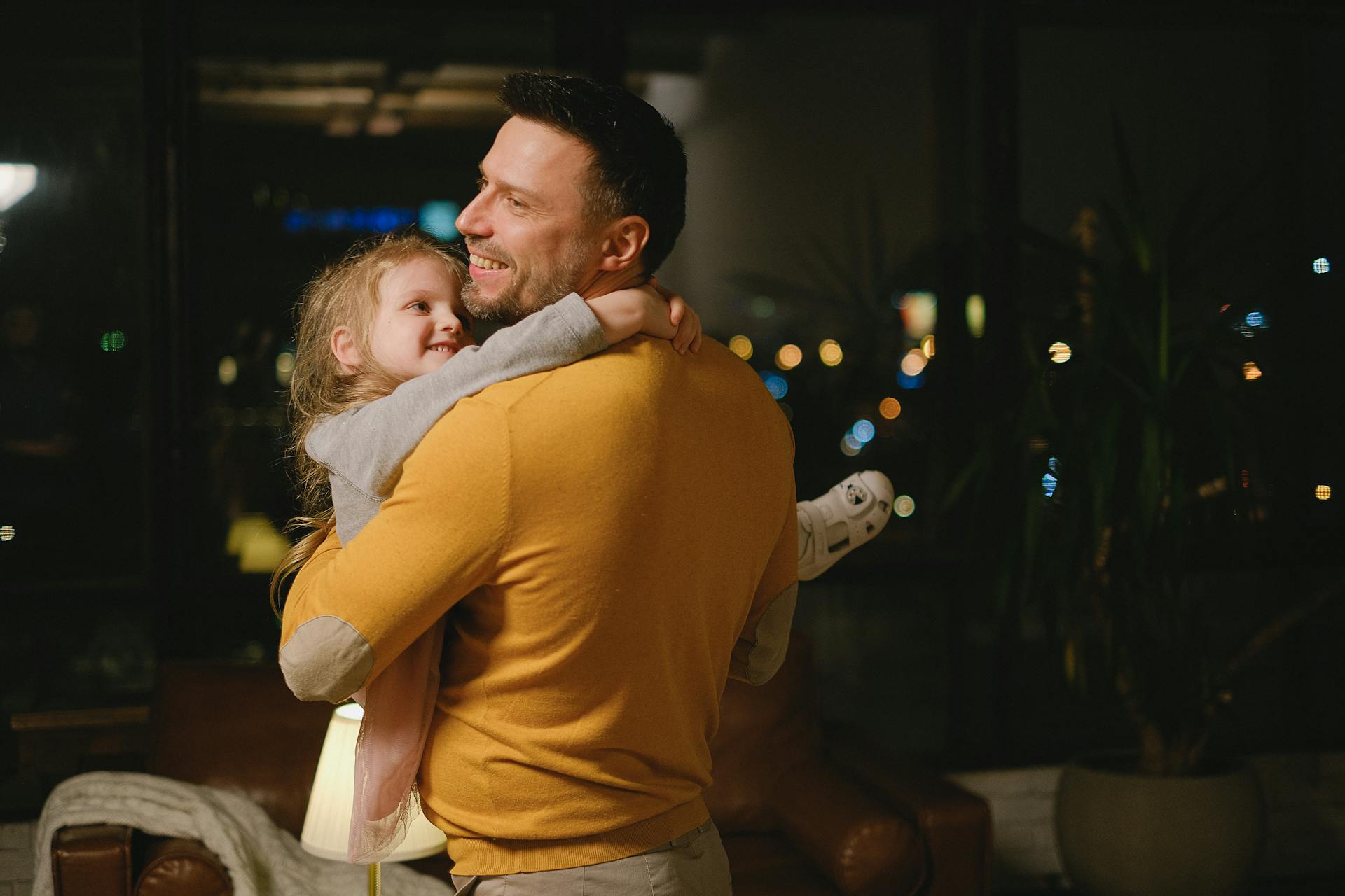 Ein Vater lächelt, während er seine kleine Tochter trägt | Quelle: Pexels