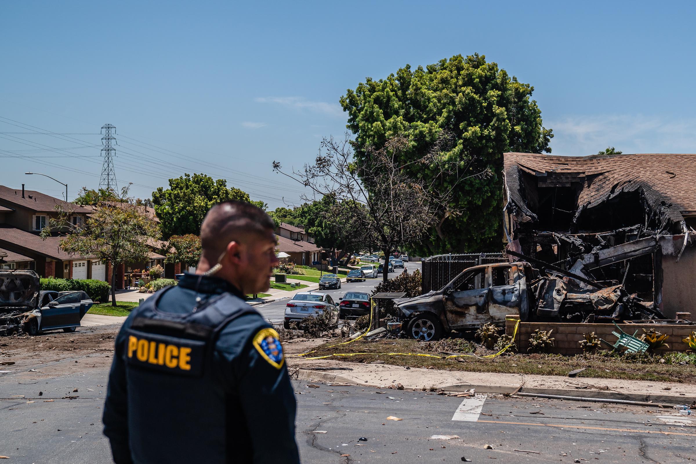 Ein Polizeibeamter untersucht den Tatort, nachdem ein Kleinflugzeug in ein Haus in San Diego gestürzt ist und schwere Brandschäden verursacht hat (22. Mai 2025): Getty Images