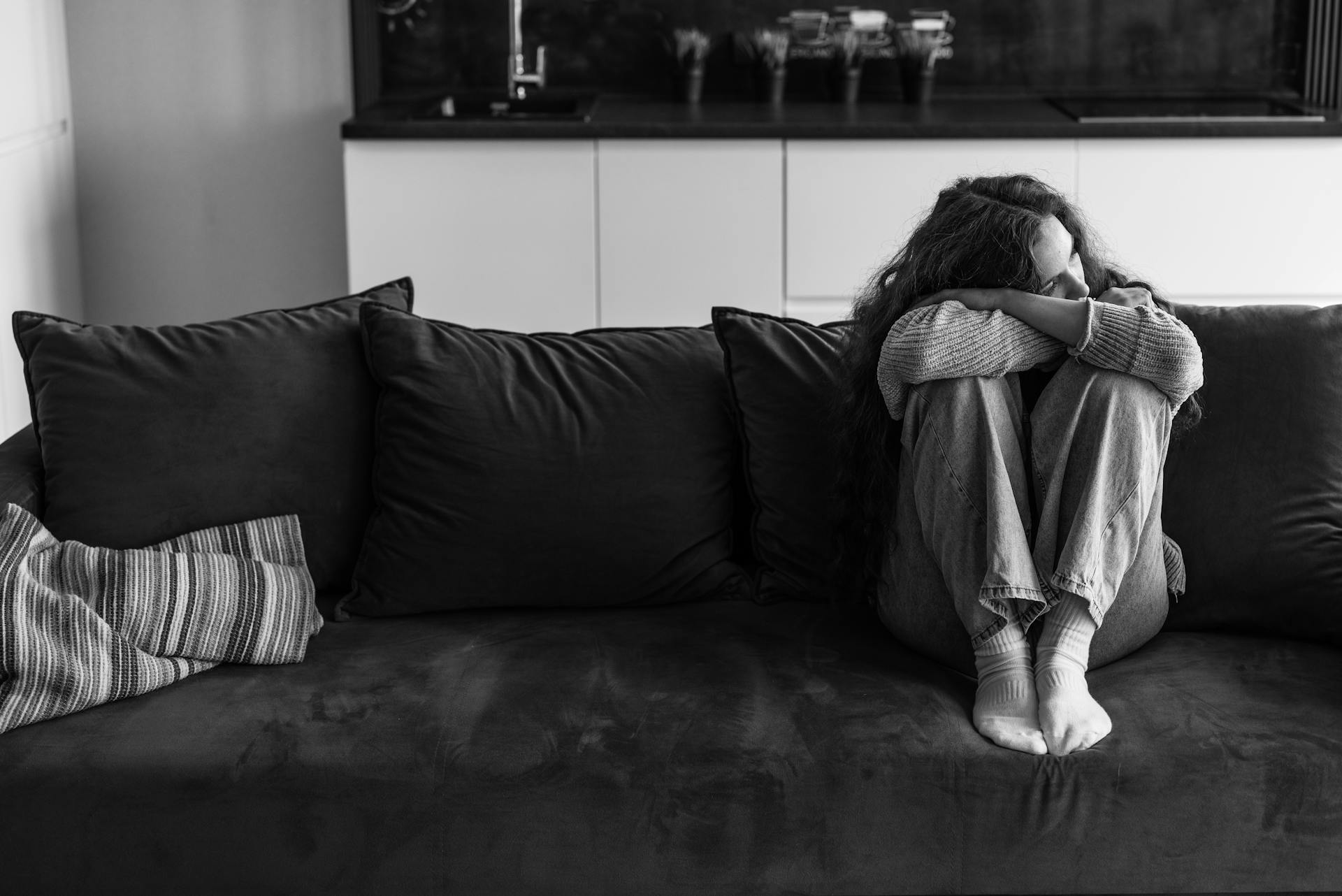 Eine traurige Frau, die auf der Couch sitzt | Quelle: Pexels