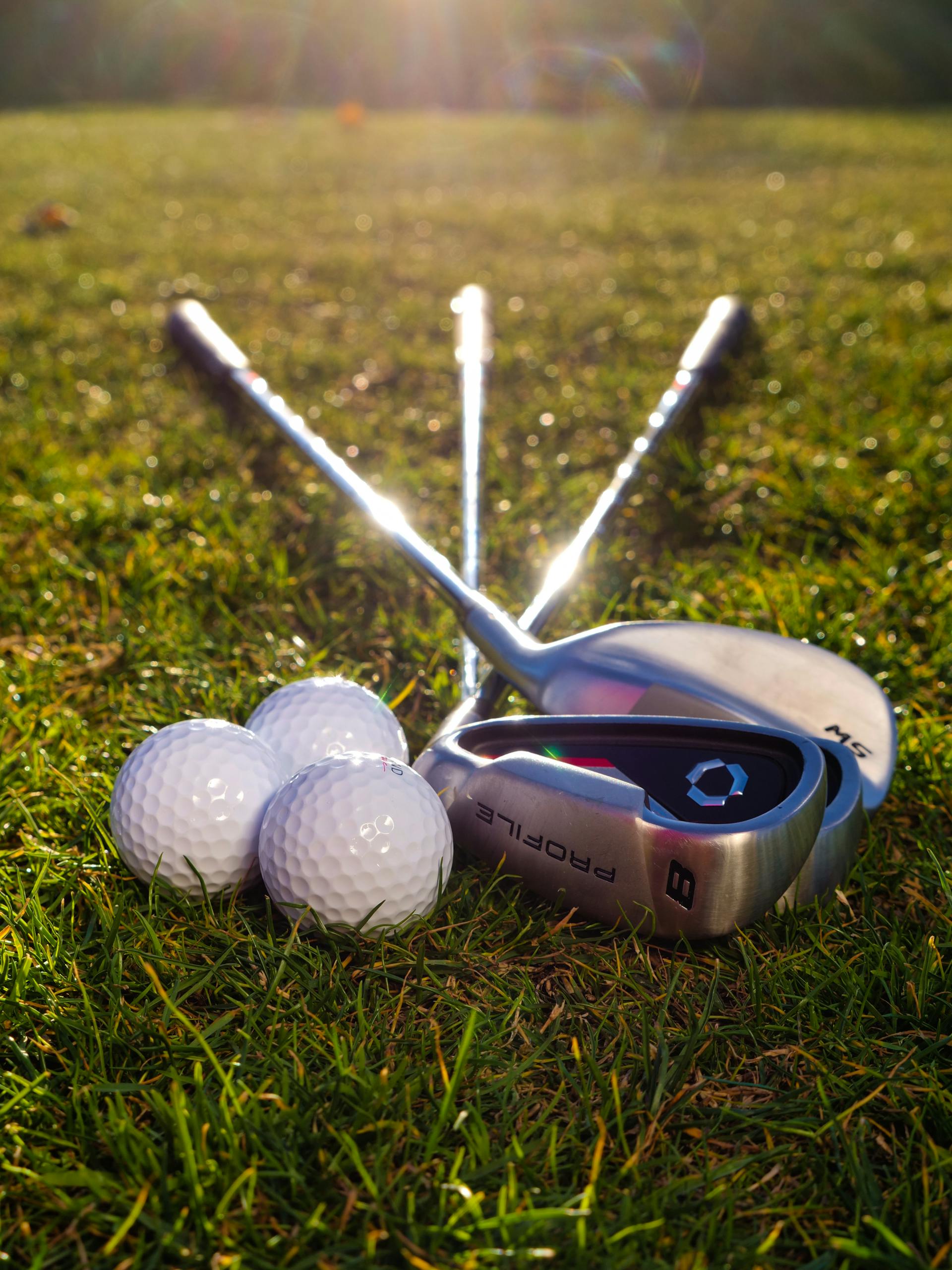 Golfbälle und Golfschläger liegen auf dem Rasen | Quelle: Pexels