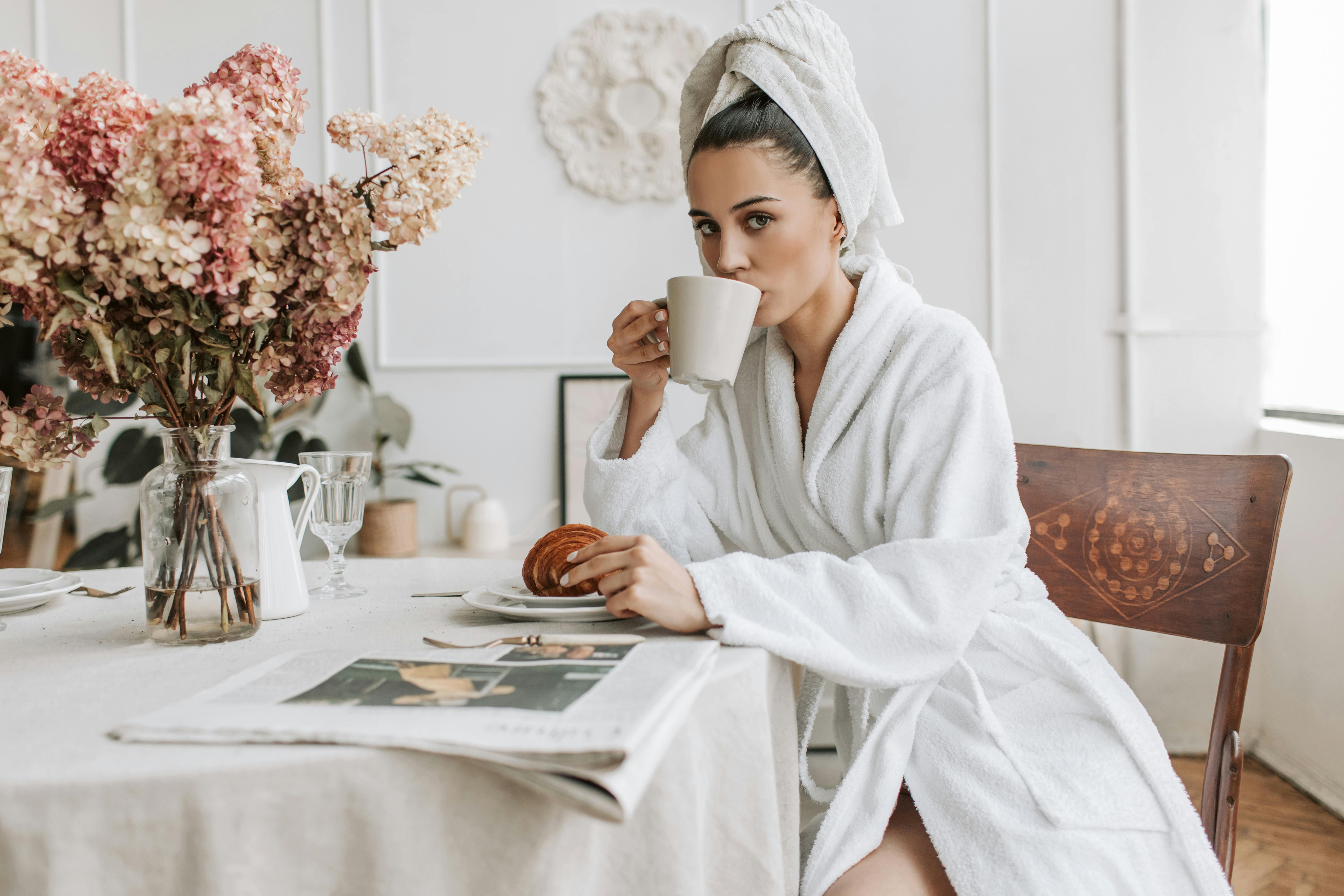 Eine Frau starrt nach vorne, während sie Kaffee trinkt | Quelle: Pexels