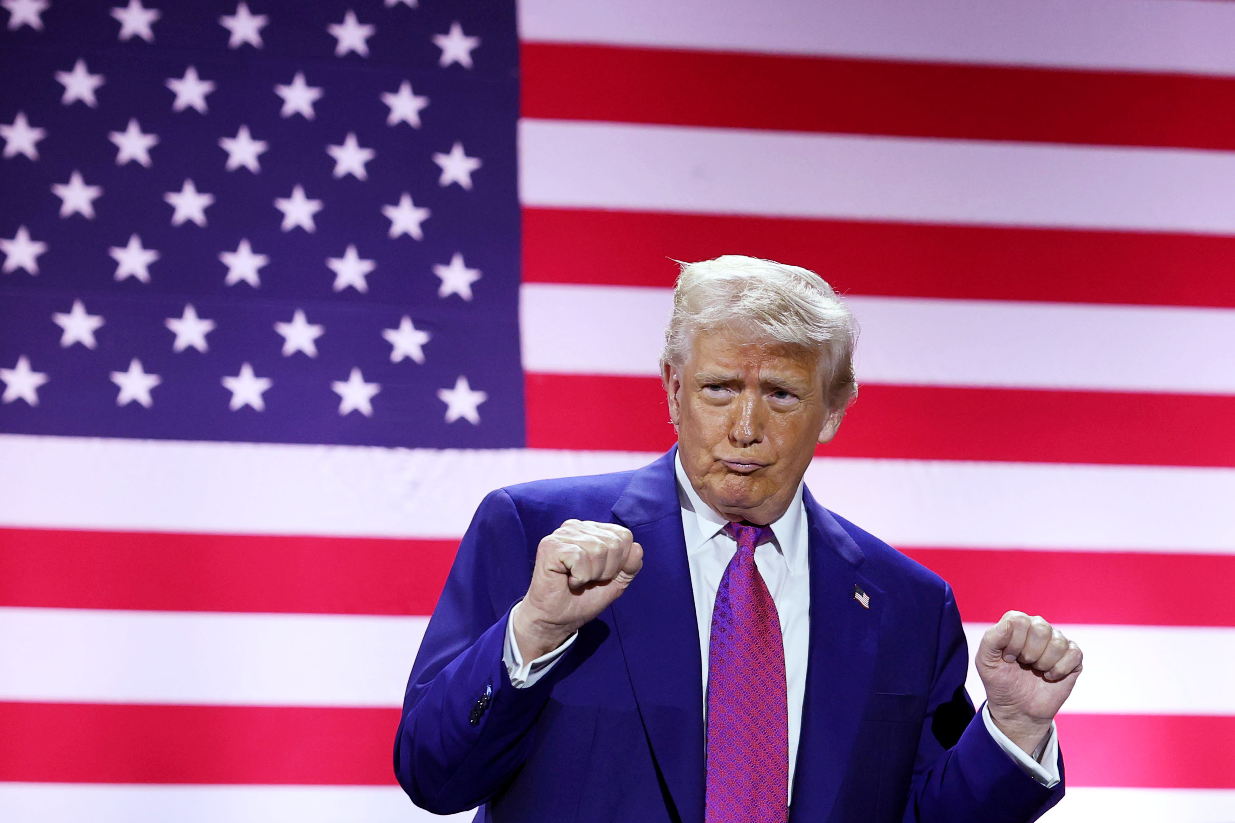 Präsident Donald J. Trump gestikuliert auf der Bühne, als er am 15. Mai 2025 den Luftwaffenstützpunkt Al Udeid in Doha, Katar, besucht. | Quelle: Getty Images