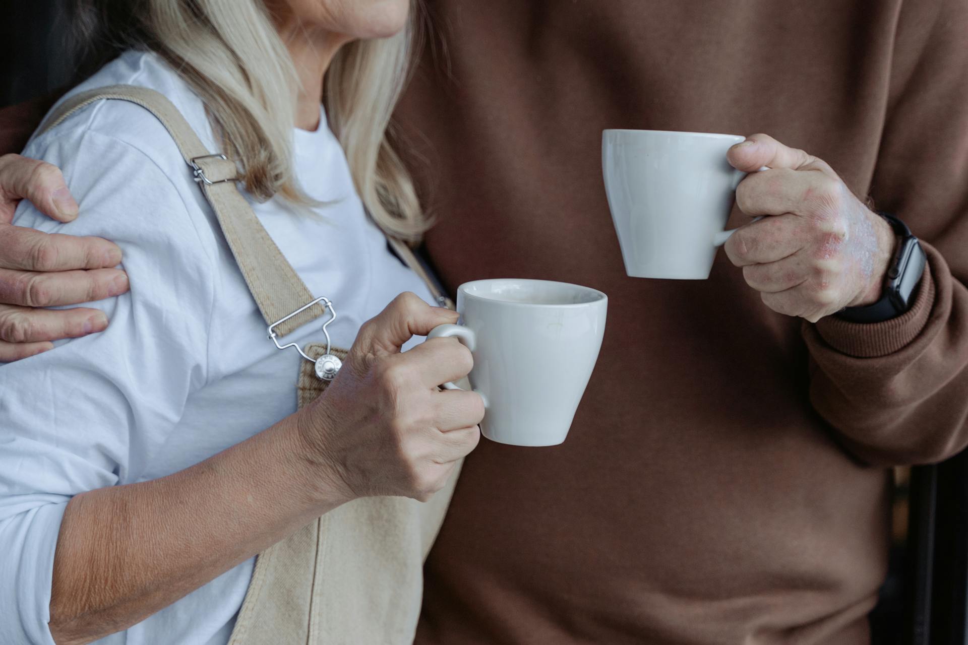 Eine Nahaufnahme eines Paares mit weißen Tassen | Quelle: Pexels
