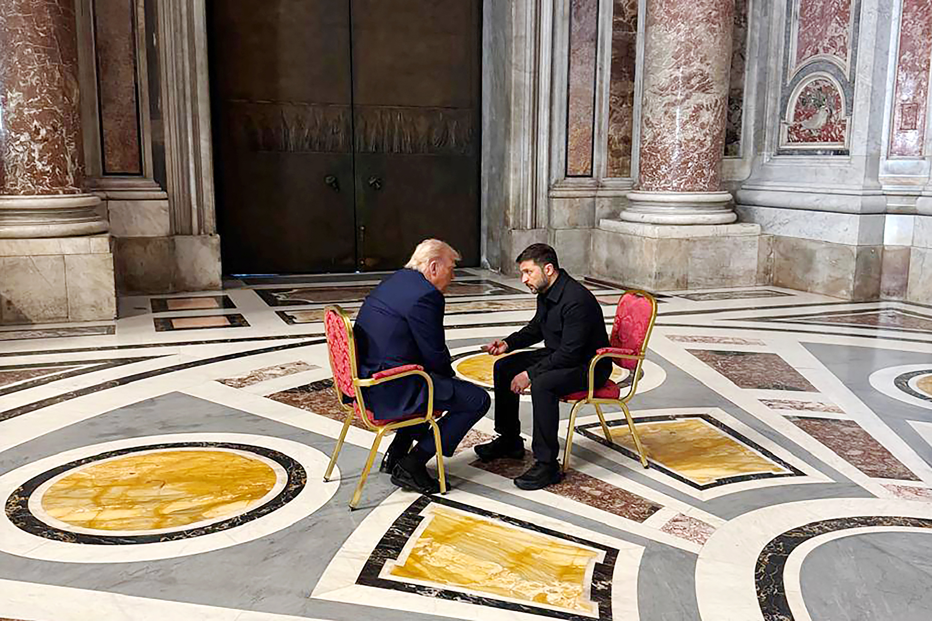 Der ukrainische Präsident Volodymyr Zelensky und Donald sitzen sich in einer Halle im Vatikan während der Beerdigung von Papst Franziskus gegenüber und unterhalten sich angeregt.