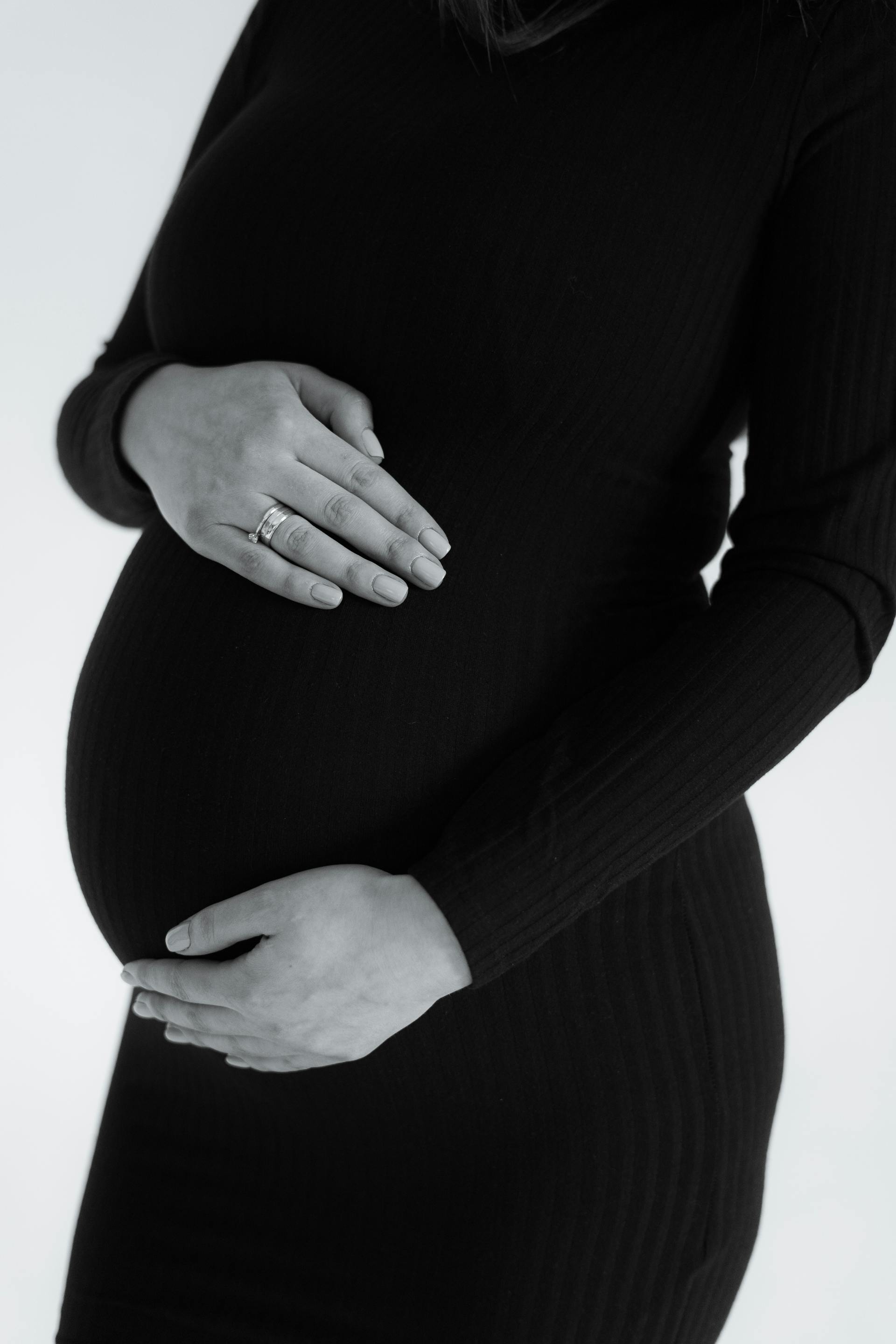Graustufenfoto einer Frau, die ihren Babybauch hält | Quelle: Pexels