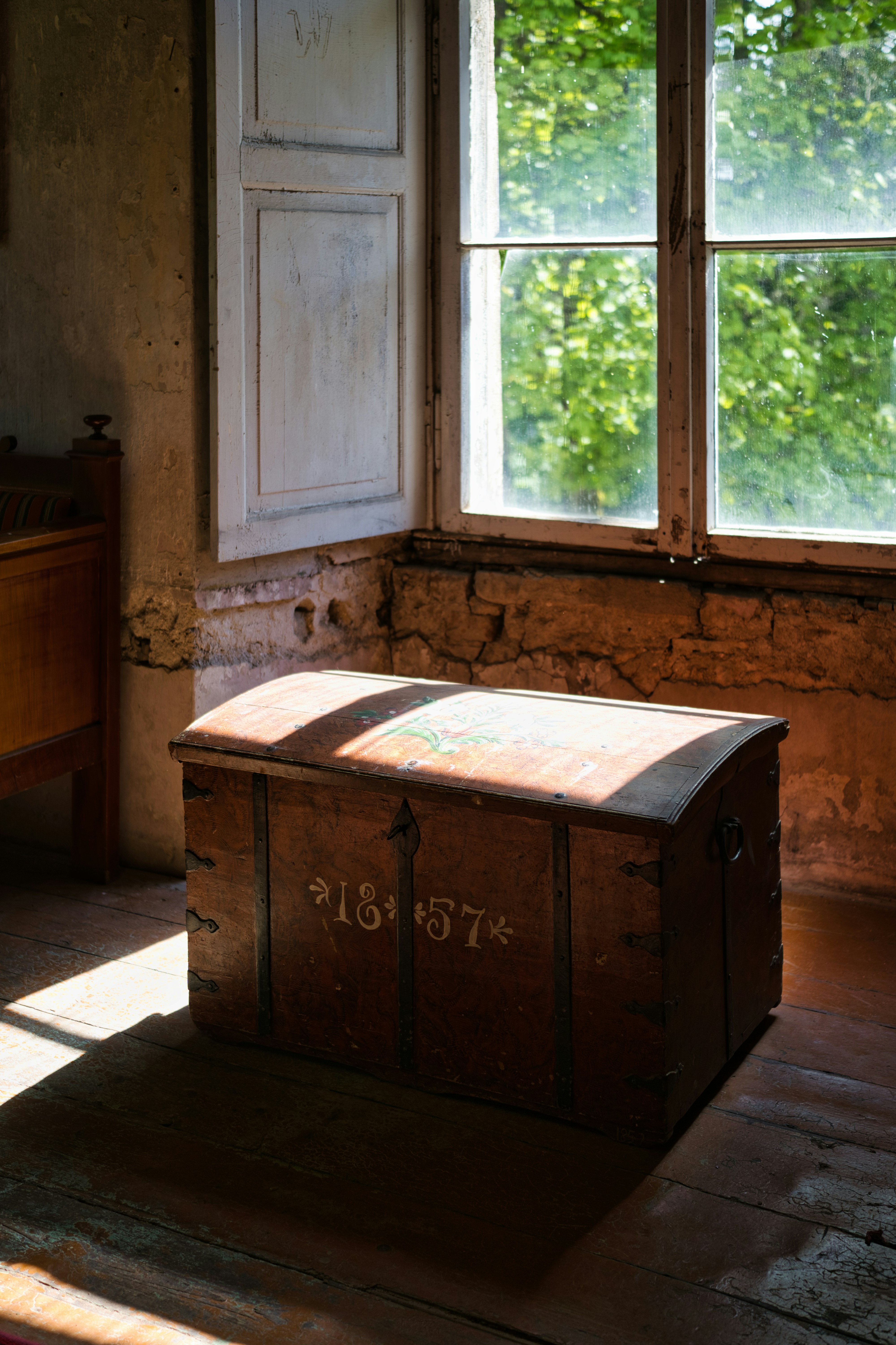 Eine antike Kiste neben einem Fenster | Quelle: Unsplash