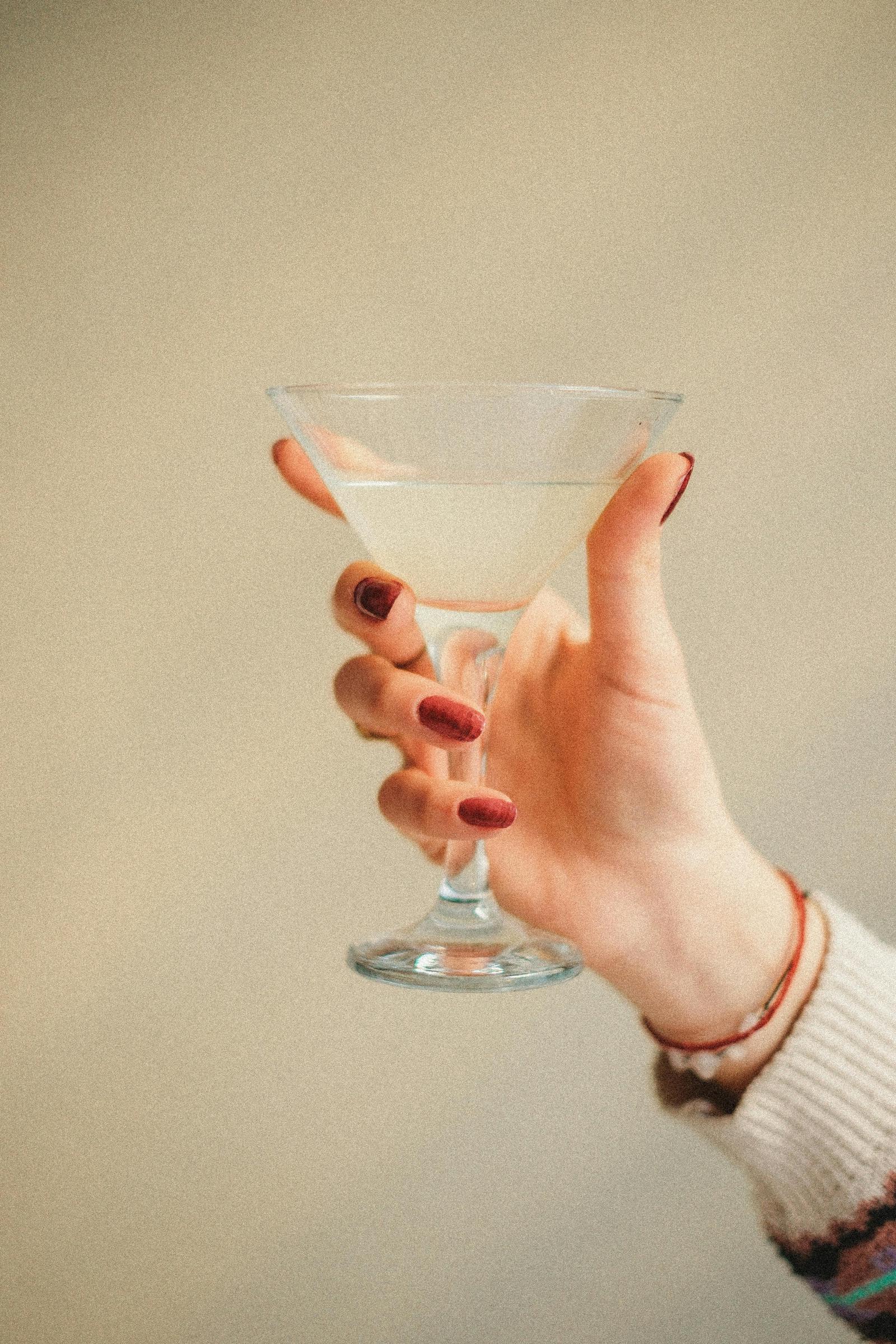 Eine Frau hält ihr Glas hoch | Quelle: Pexels