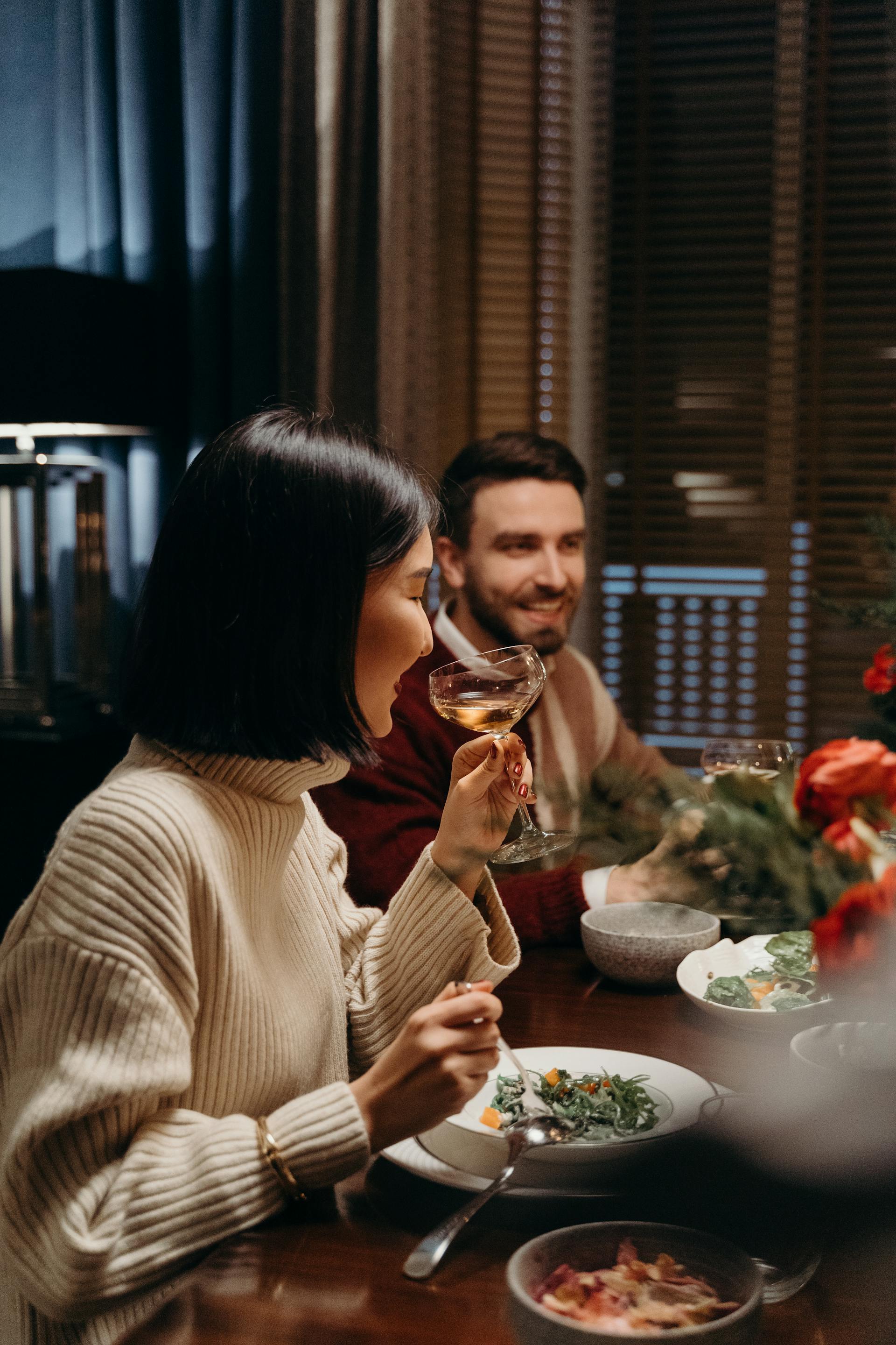Ein Mann lächelt, während er mit anderen zu Abend isst | Quelle: Pexels