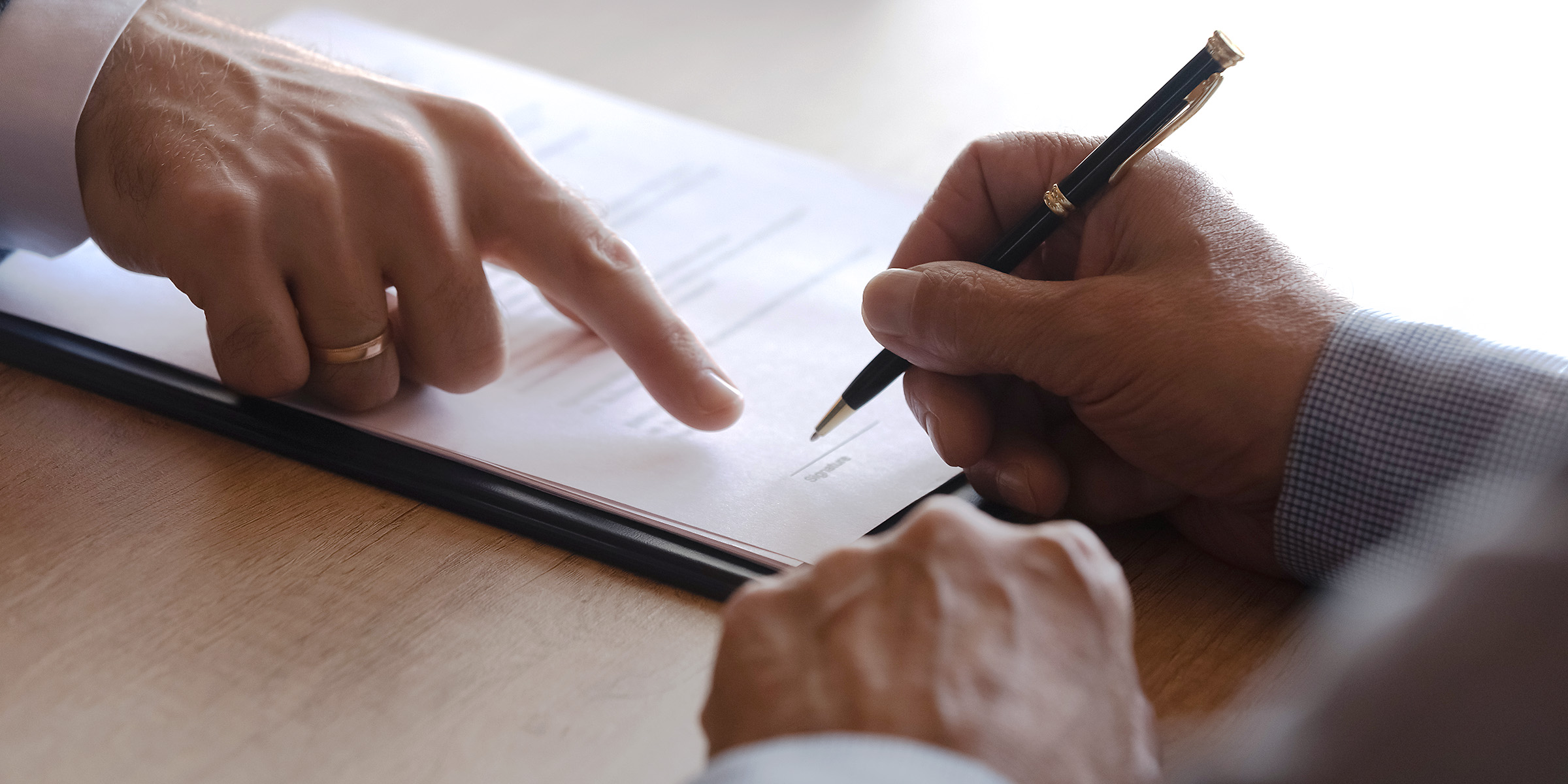 Jemand unterschreibt Papierkram | Quelle: Shutterstock