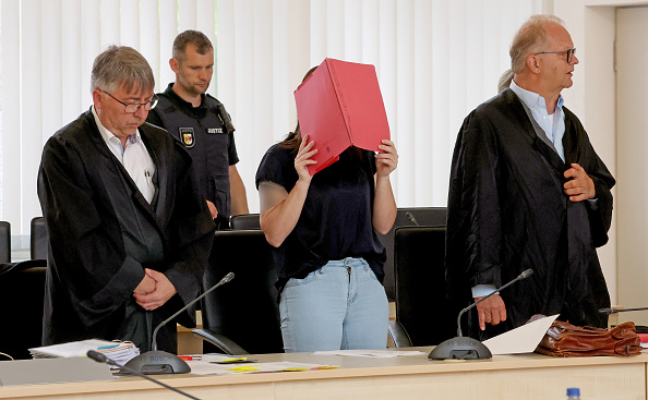 Die Angeklagte Gina mit ihren Anwälten Andreas Ohm und Thomas Löcker erheben sich beim Eintreten des Gerichts, Rostock, 27. Mai 2026. | Quelle: Getty Imageseck/picture alliance via Getty Images)