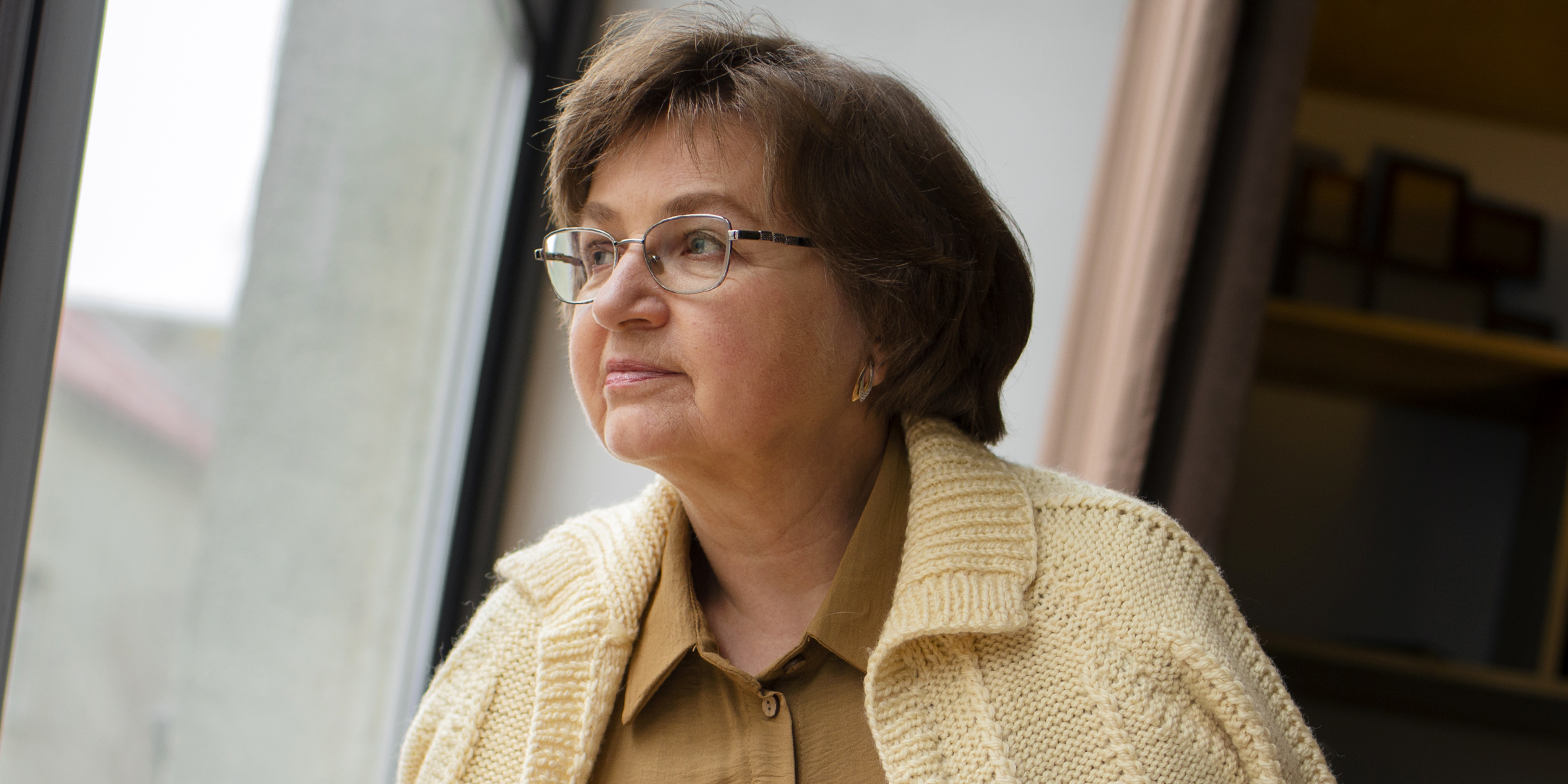Eine Frau, die nachdenklich aus dem Fenster starrt | Quelle: Freepik
