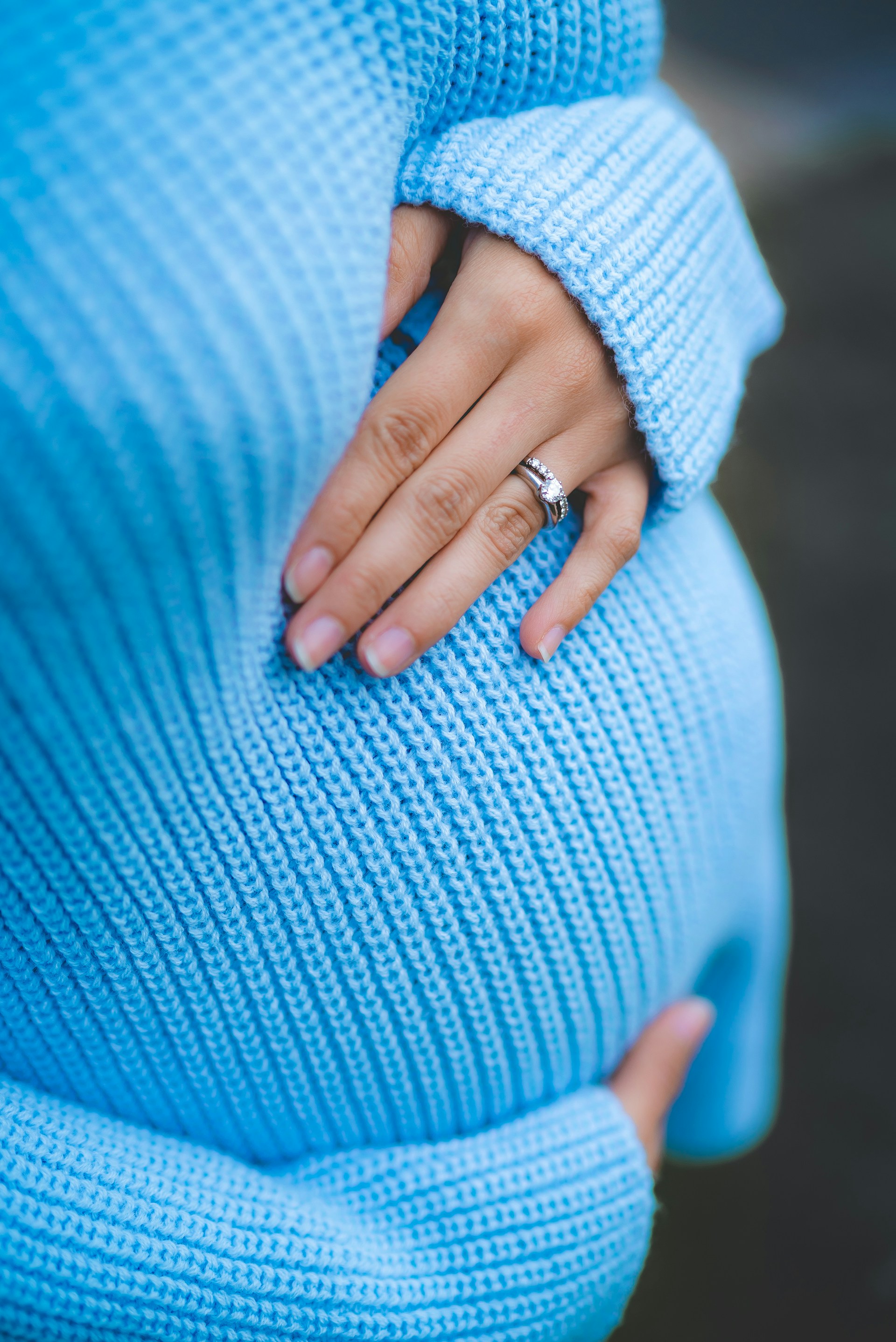 Eine schwangere Frau trägt einen blauen Pullover | Quelle: Unsplash