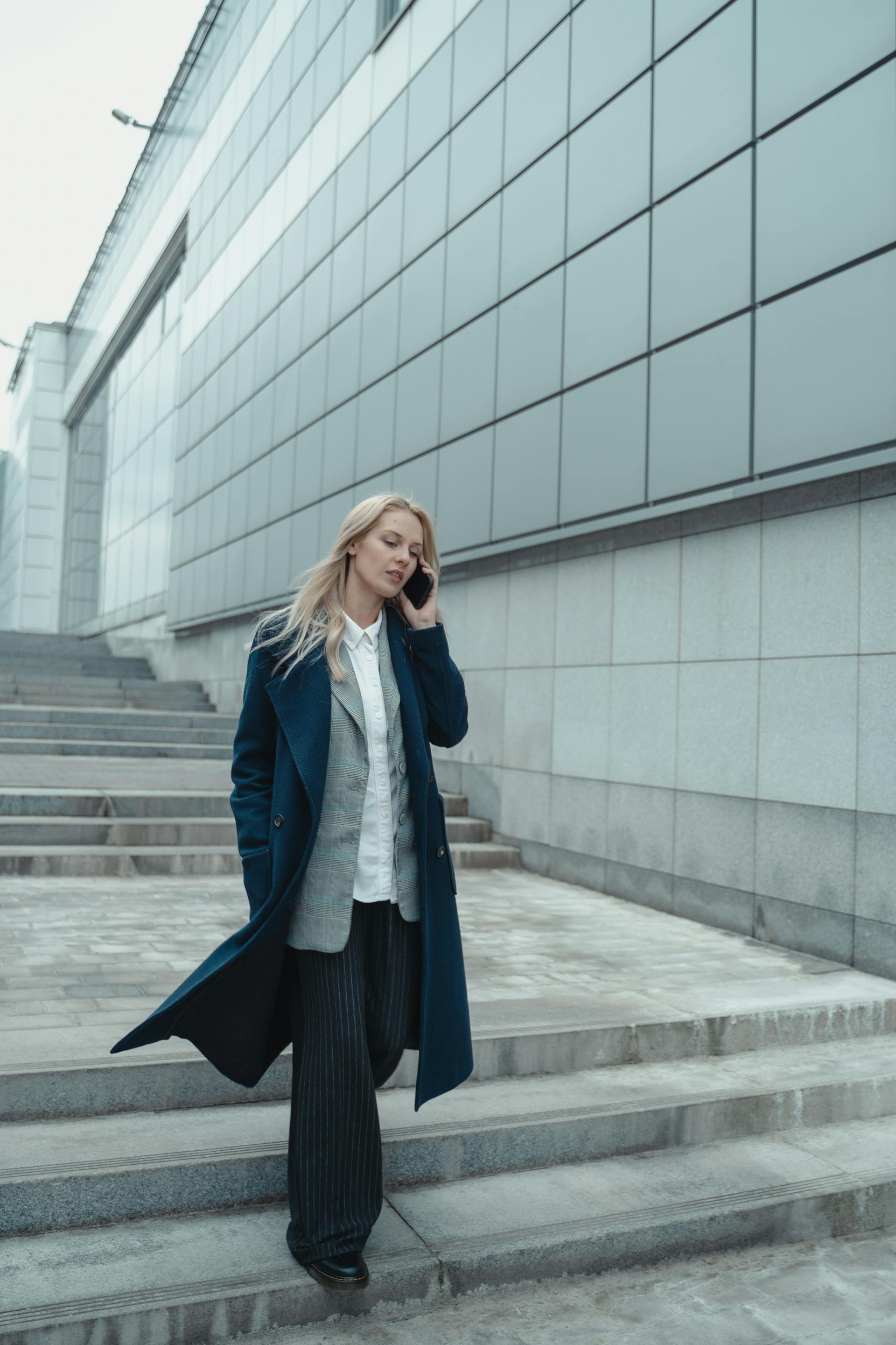 Eine Frau telefoniert, während sie eine Treppe hinuntergeht | Quelle: Pexels