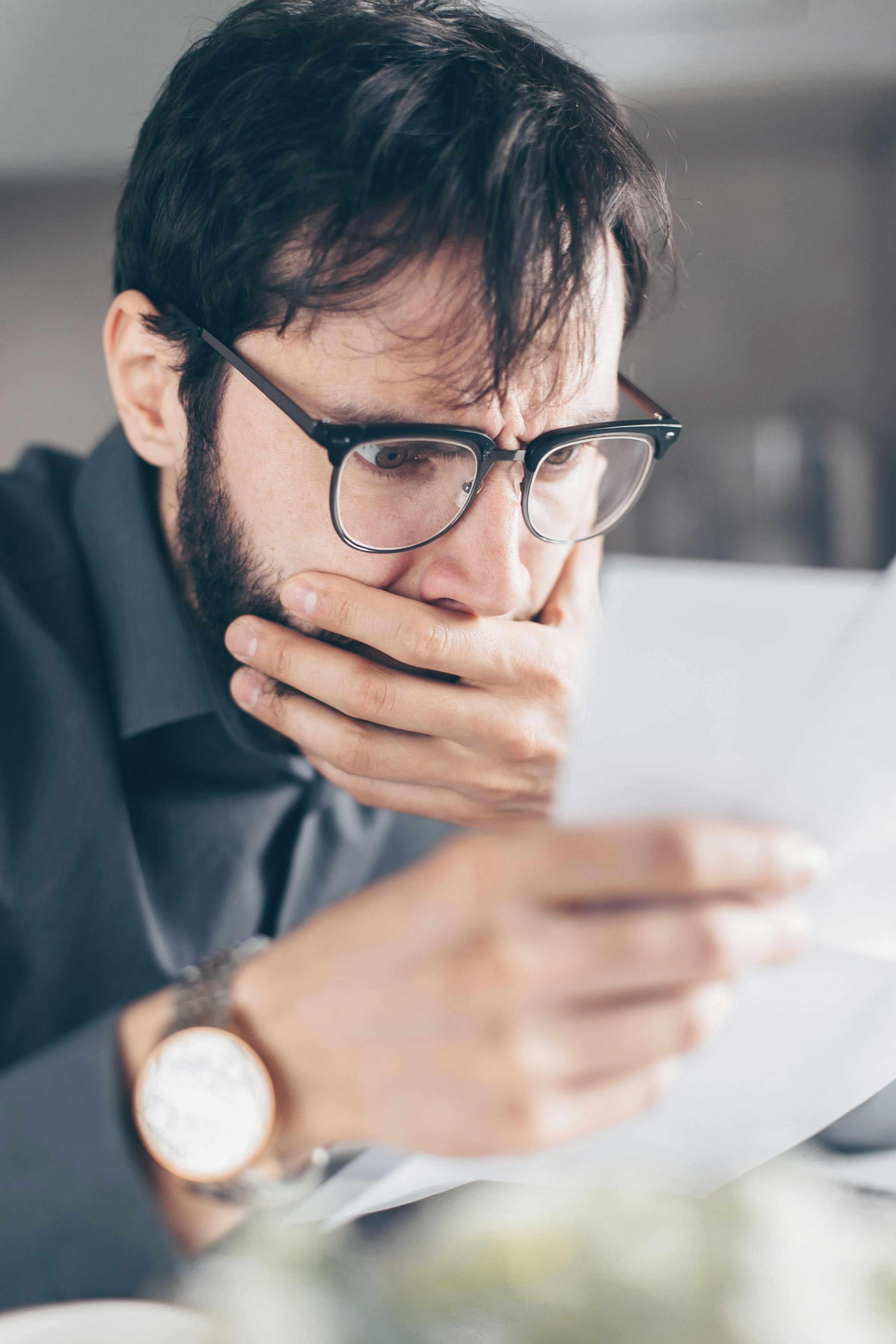 Ein geschockter Mann liest einen Zettel | Quelle: Pexels