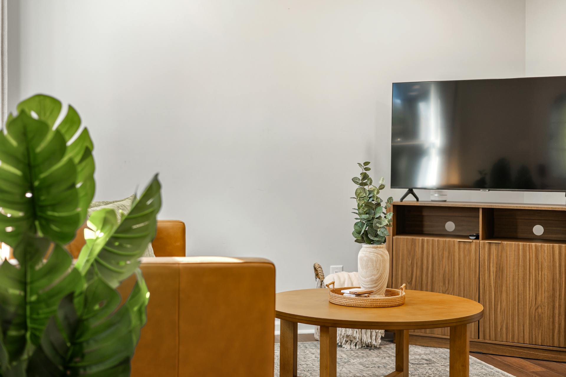 Ein Flachbildfernseher auf einem Holzgestell in einem Zimmer | Quelle: Pexels