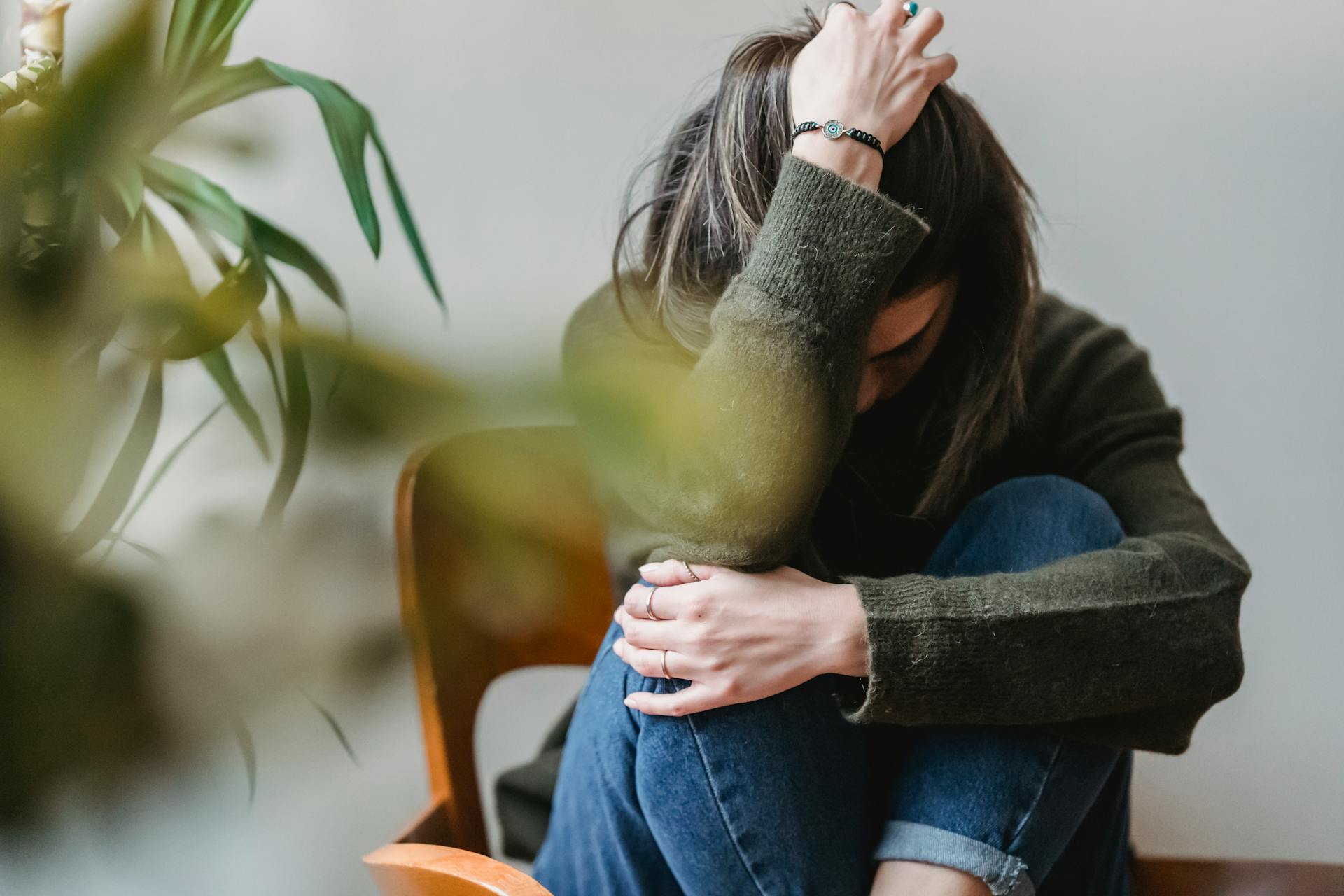 Eine Frau sitzt mit dem Kopf in einer Hand | Quelle: Pexels