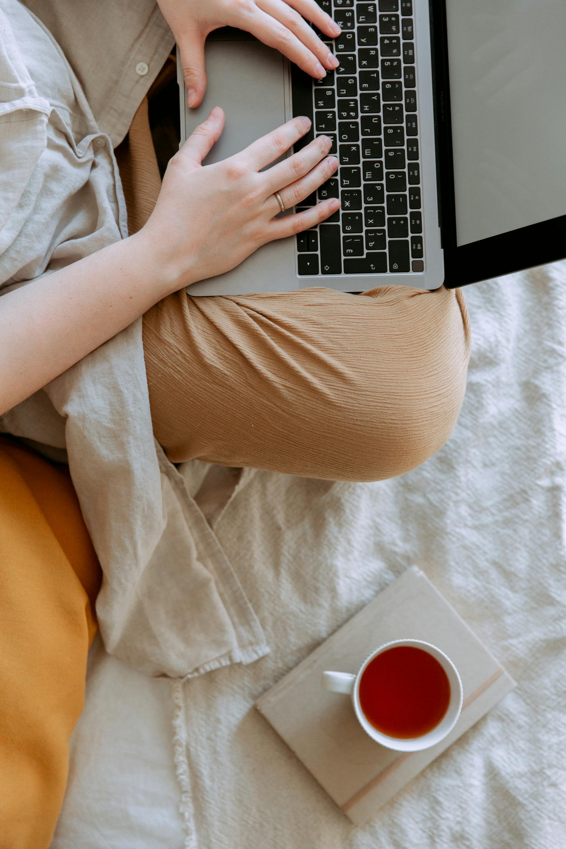 Eine Frau benutzt ihren Laptop im Bett | Quelle: Pexels