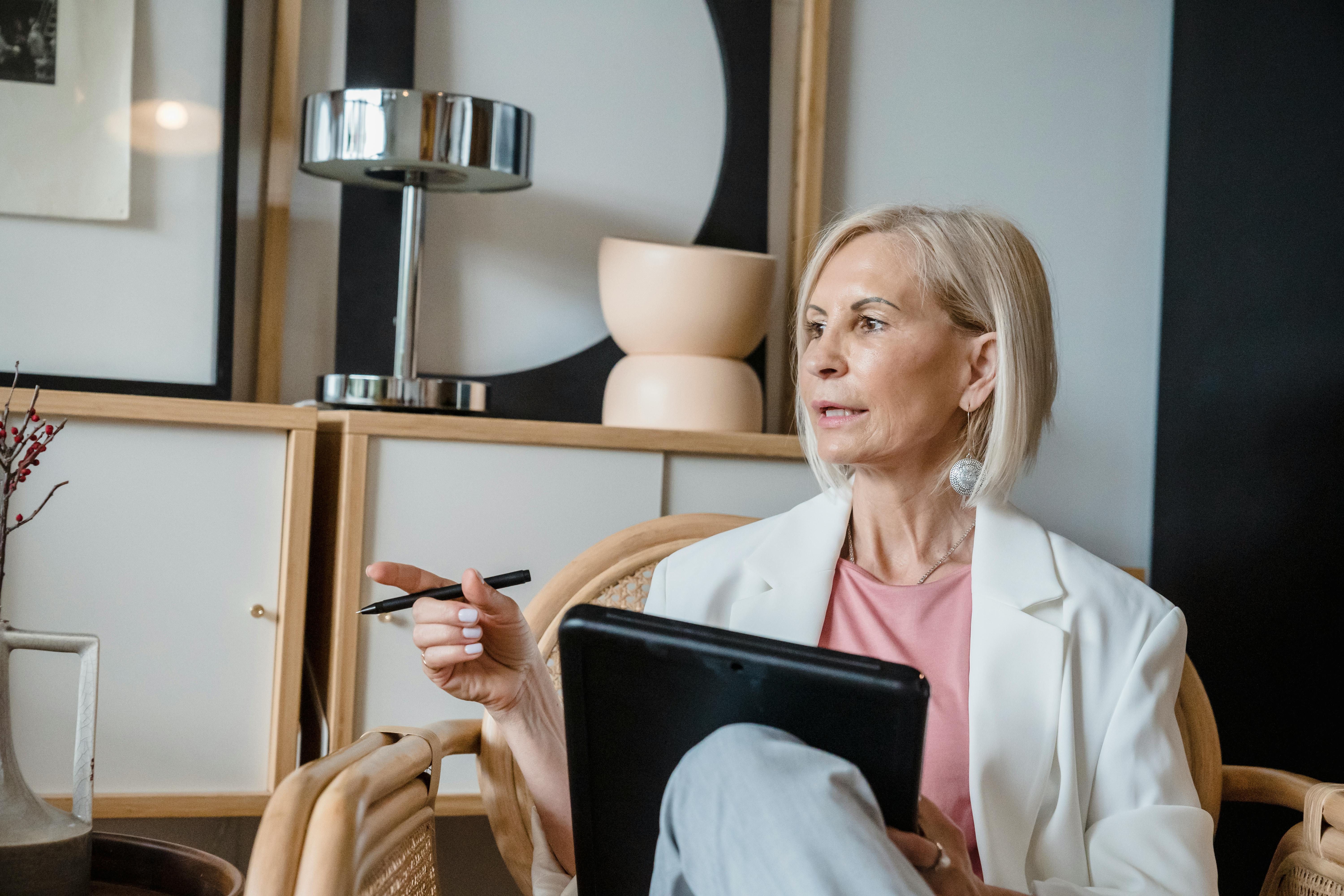 Eine Frau hält einen Stift, während sie auf einem Stuhl sitzt | Quelle: Pexels