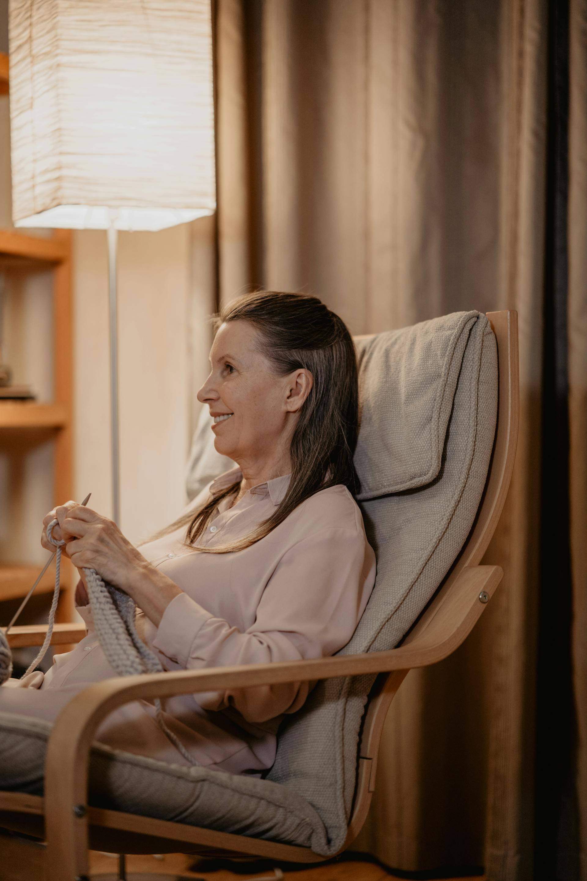 Eine ältere Frau, die auf einem Stuhl sitzt und strickt | Quelle: Pexels